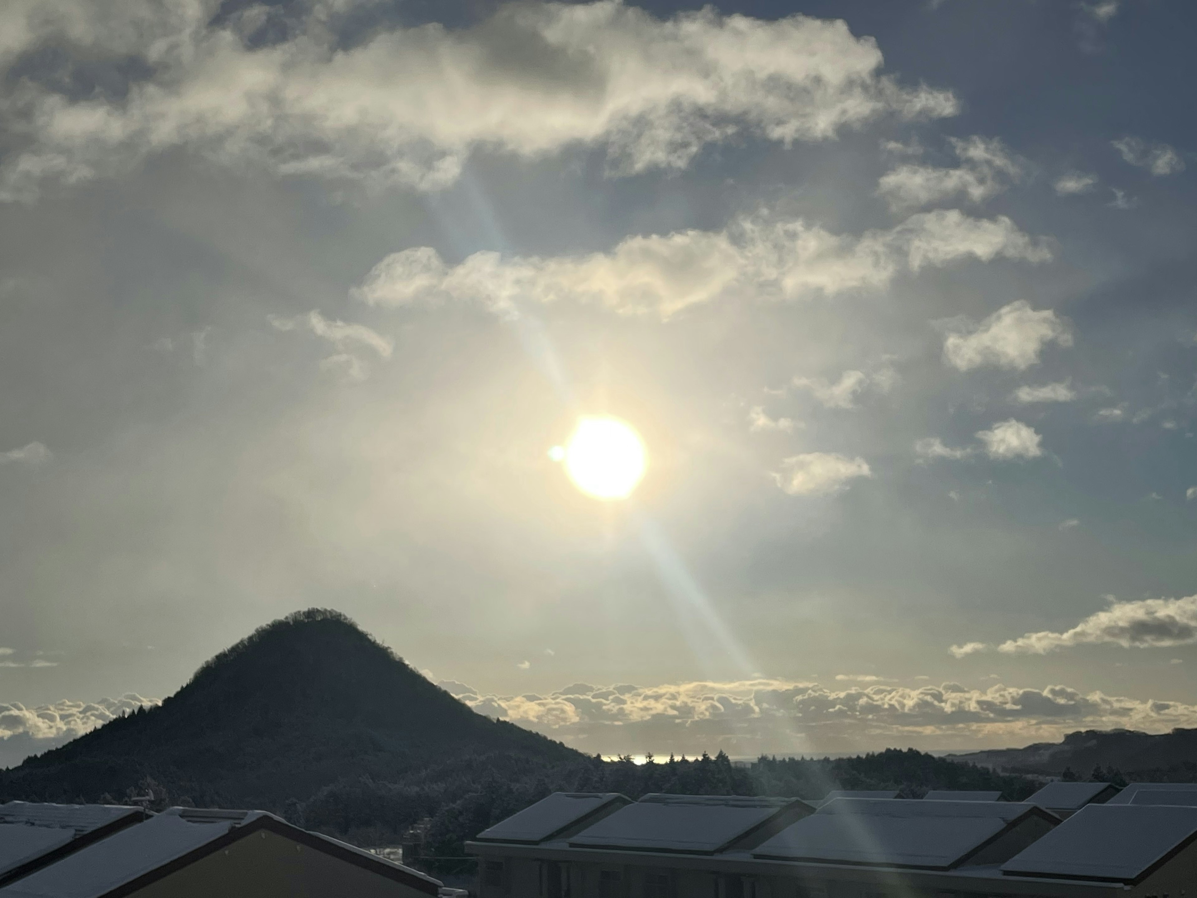 雪が積もった山と太陽の光が輝く空の景色