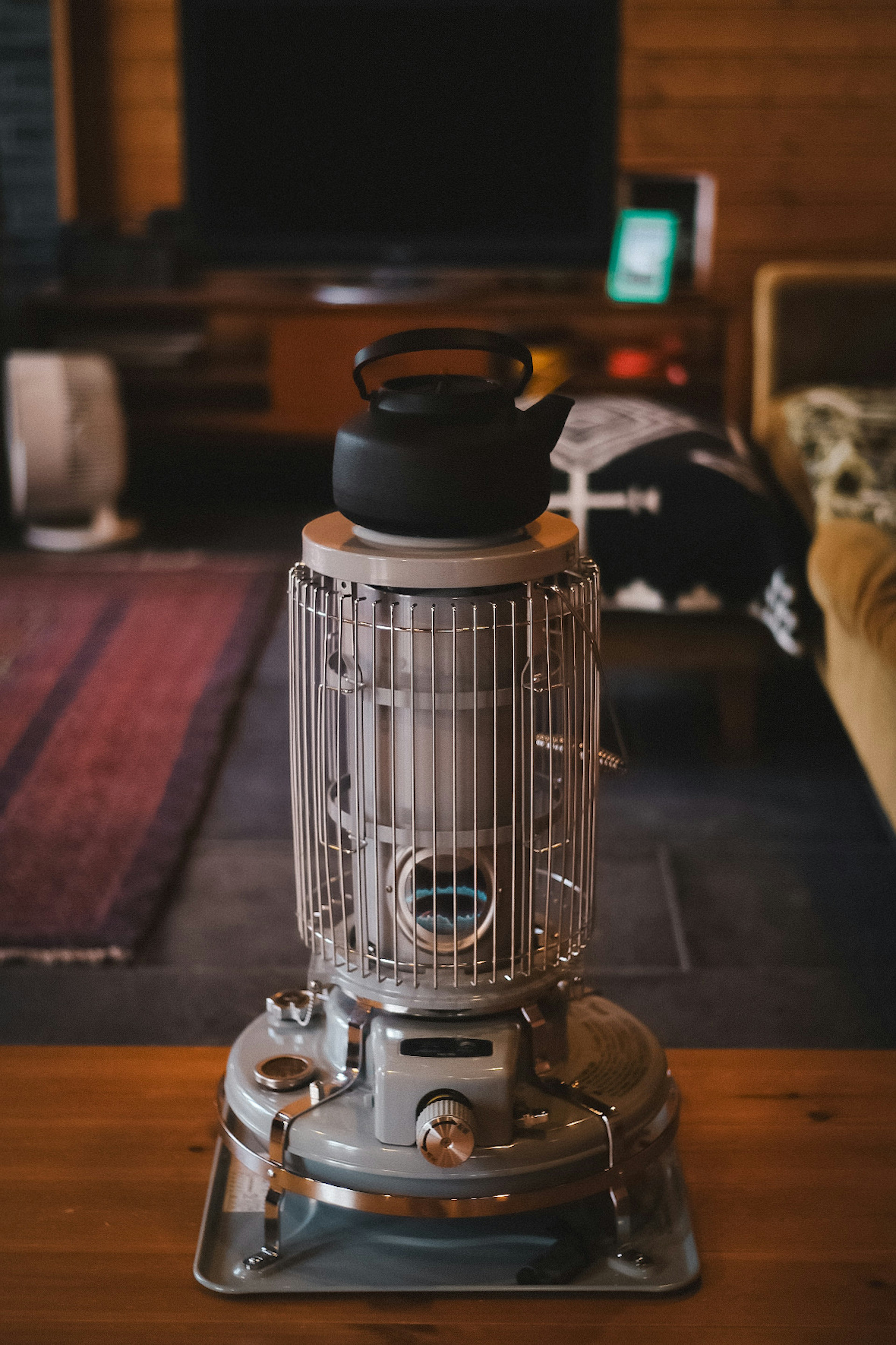 A vintage heater with a kettle in a cozy living room