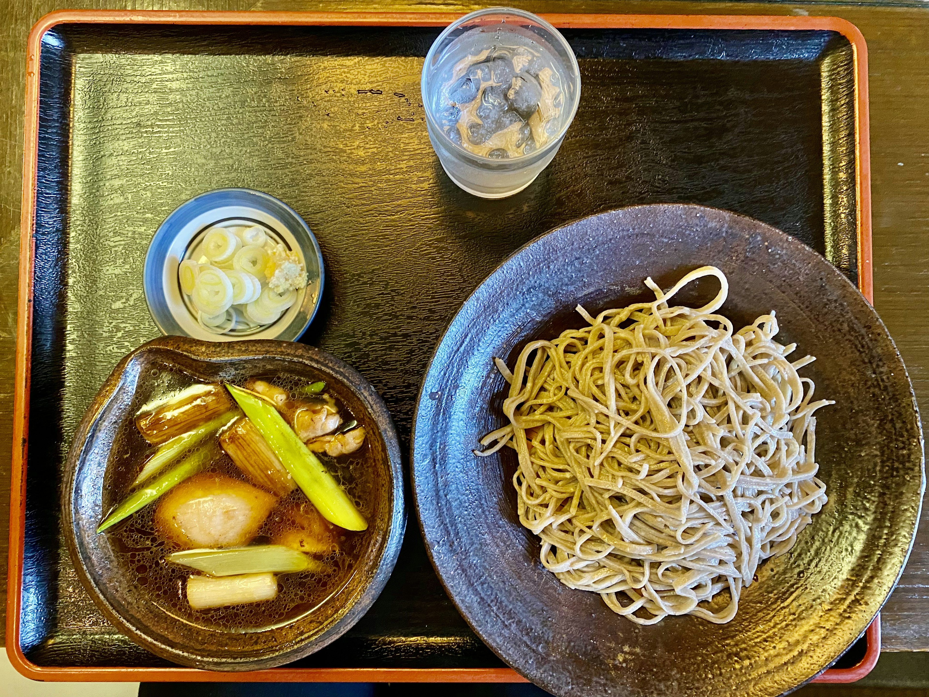 Un pasto con noodles soba, salsa di immersione e un contorno di sottaceti