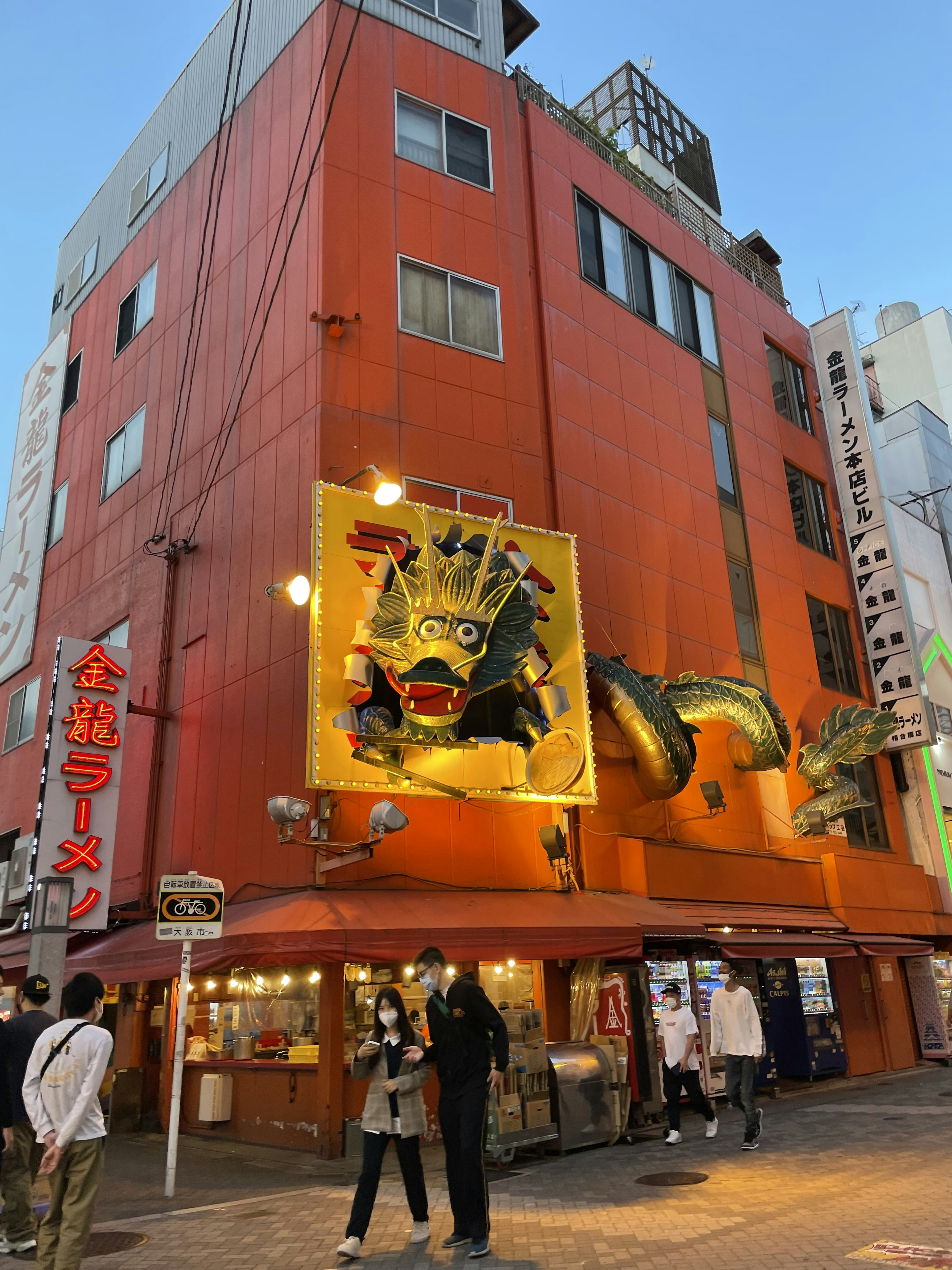 Edificio naranja vibrante con un gran cartel en una escena urbana bulliciosa