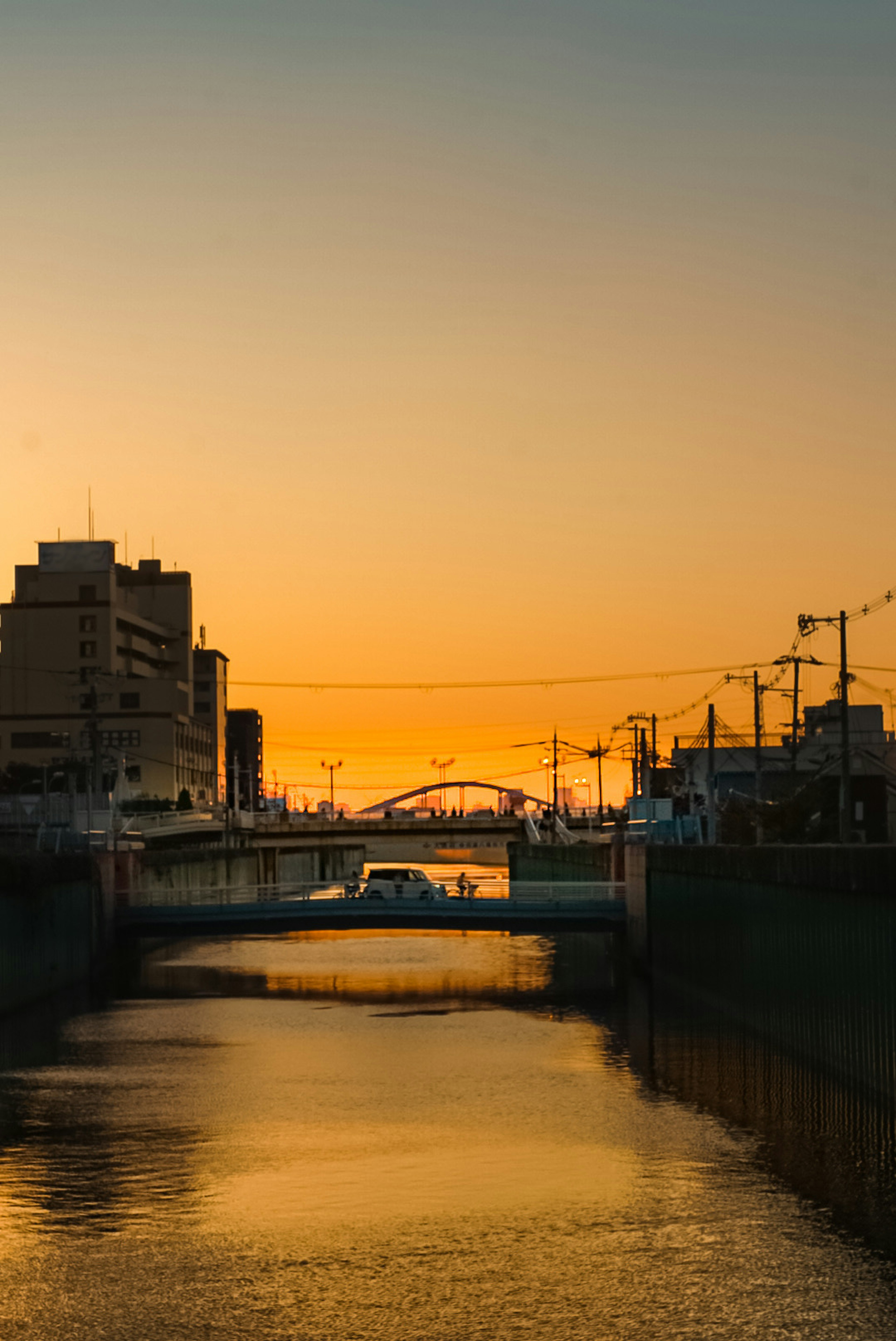 夕焼けに照らされた川と橋の風景