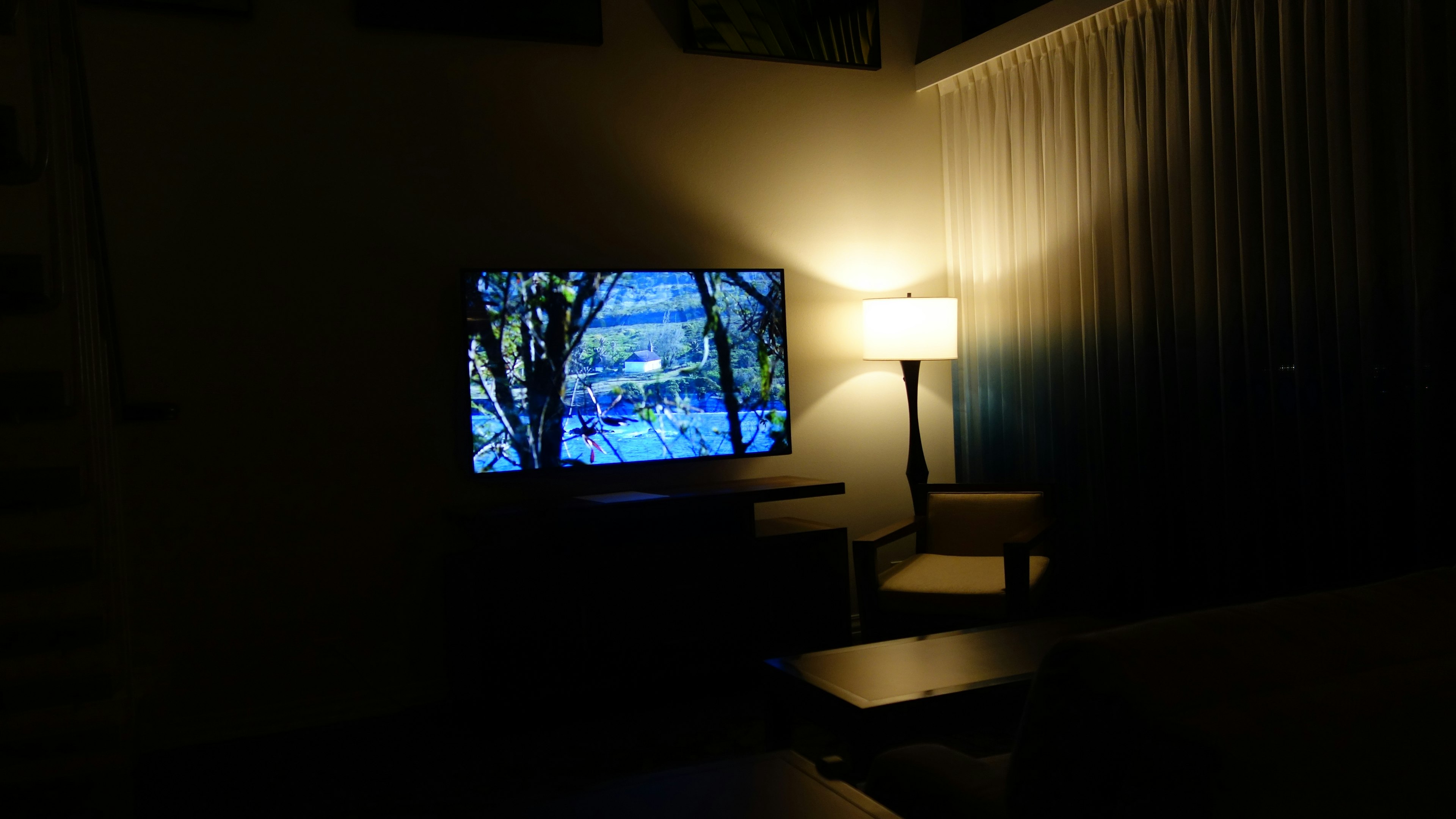 Una habitación poco iluminada con un televisor y una lámpara