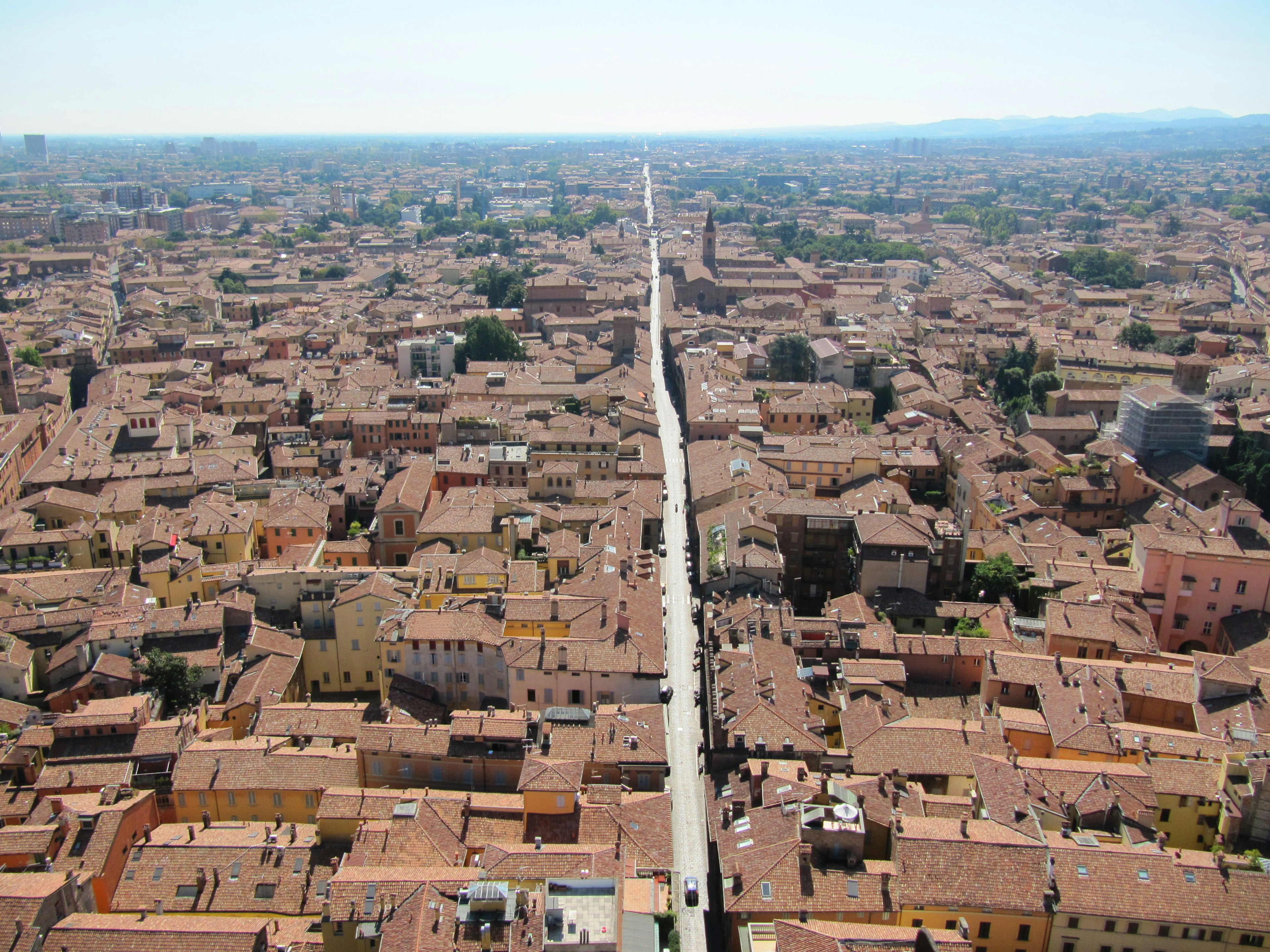 Aerial view of terracotta rooftops and a long straight road