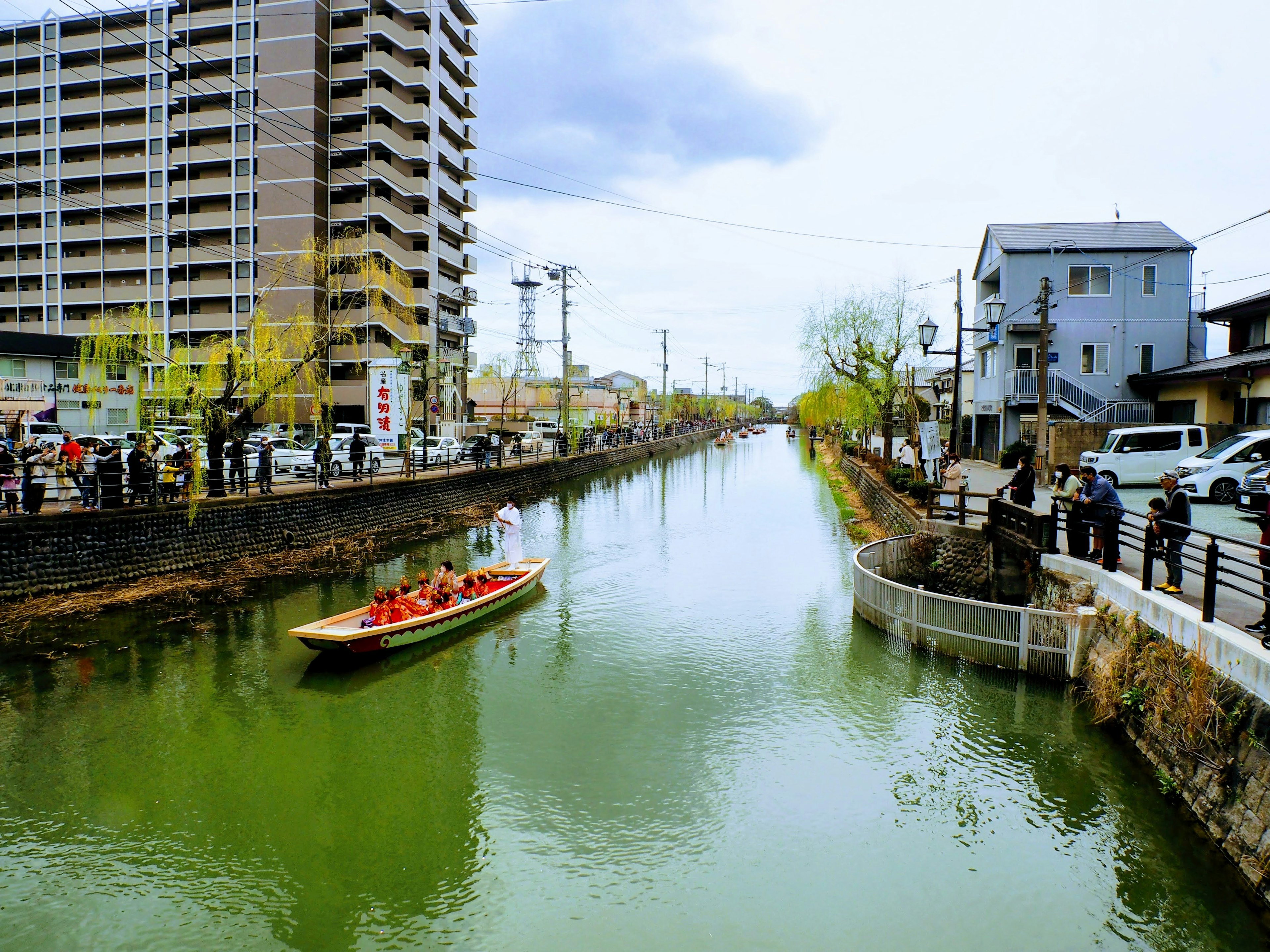 Vista escénica de un bote en un río verde rodeado de edificios