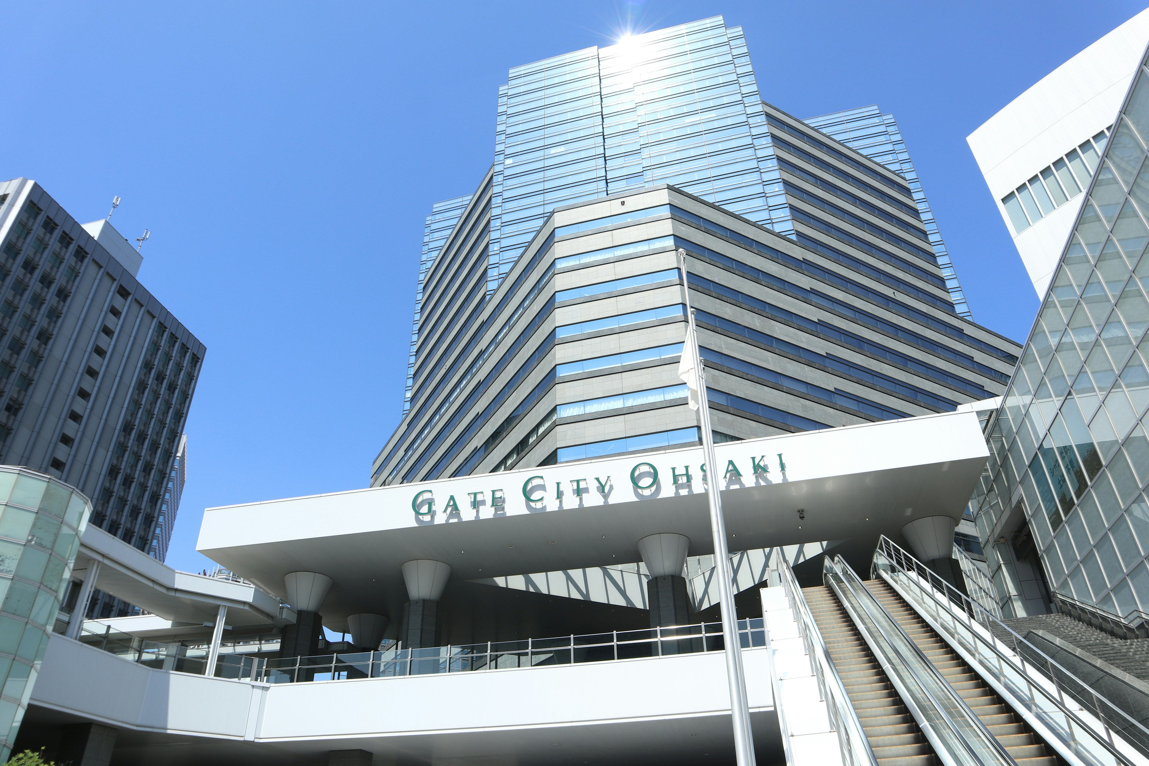 Exterior view of Niigata City Station with skyscrapers under a bright blue sky