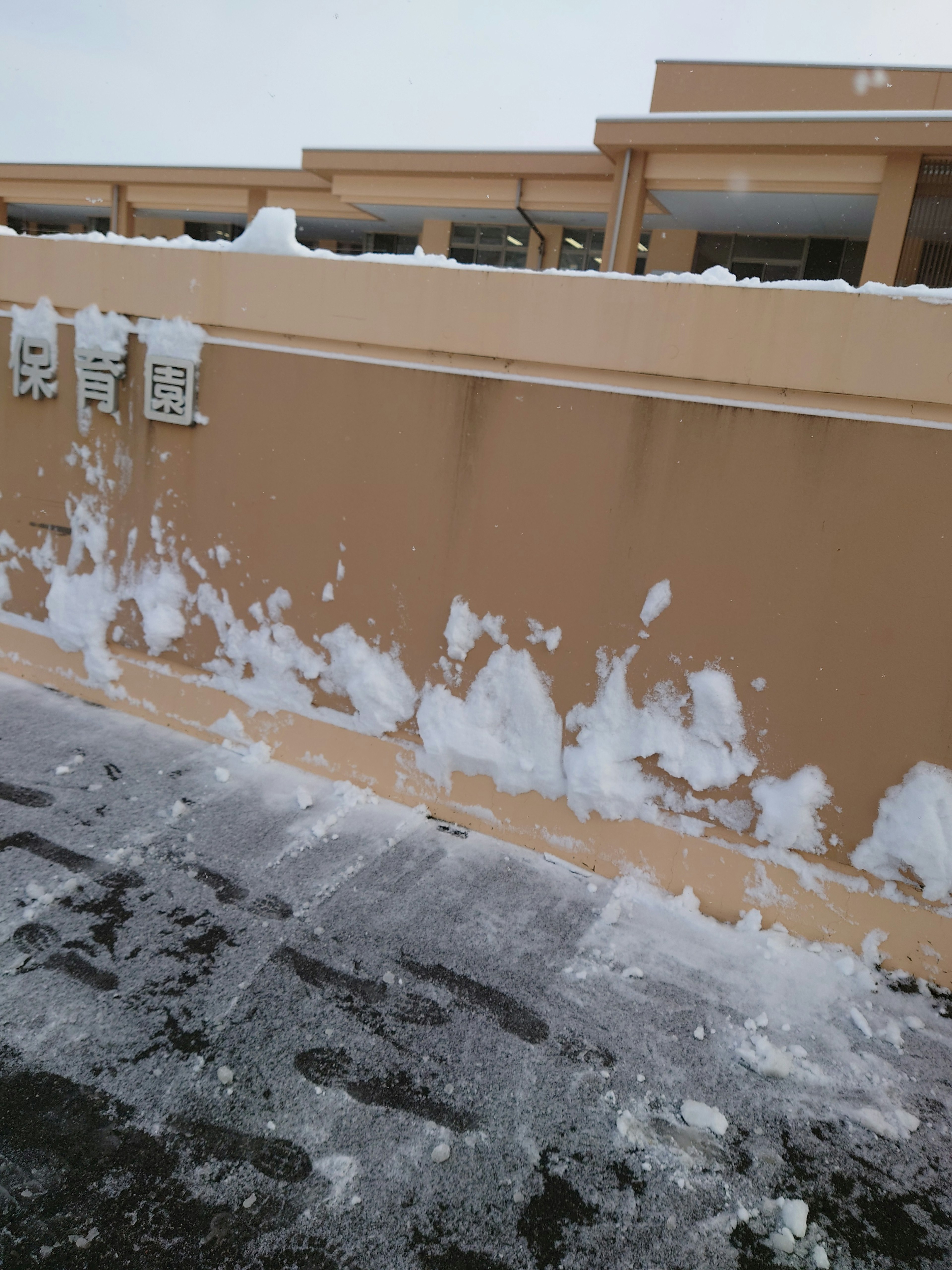 雪が積もった壁と地面の様子を示す画像