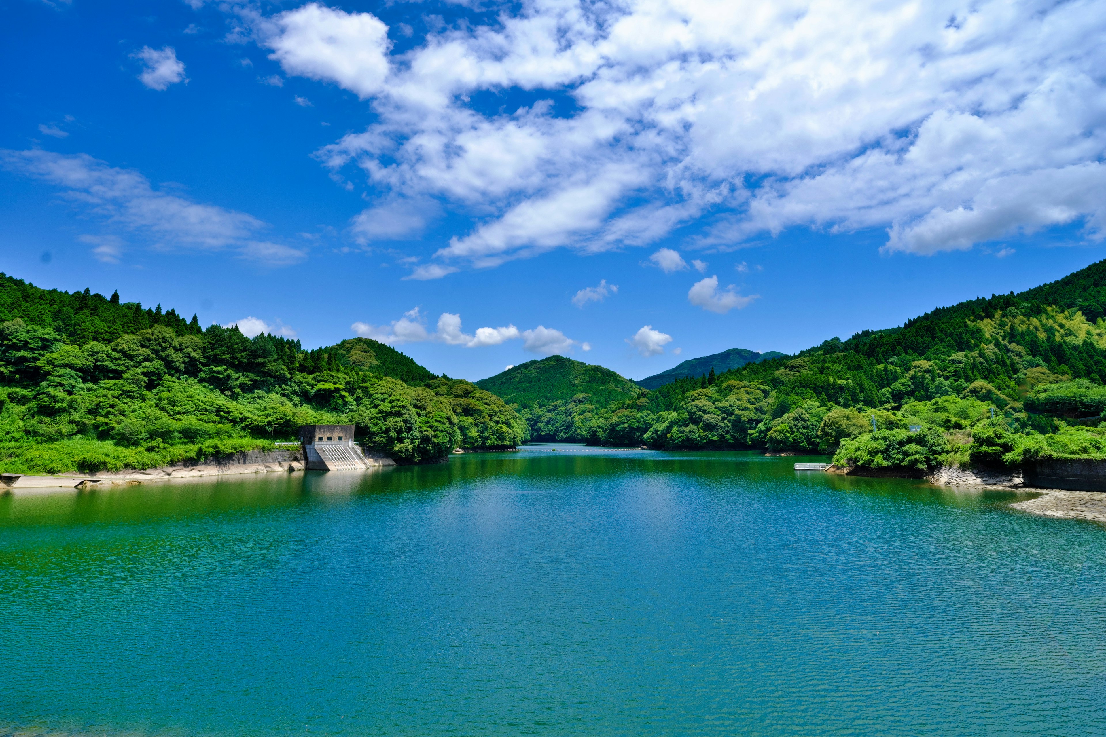 Vista escénica de un lago azul rodeado de montañas verdes