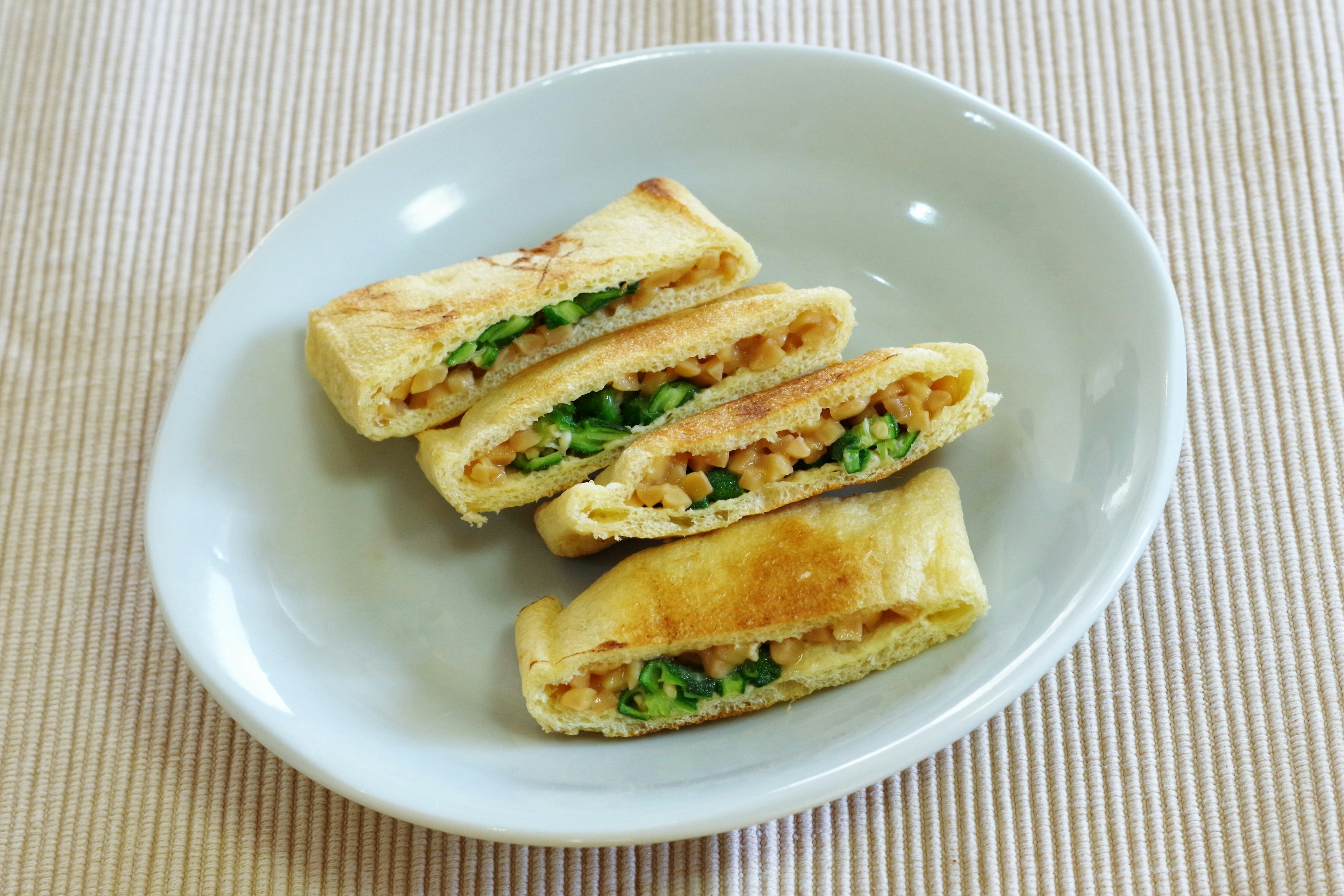 Tres tortillas enrolladas rellenas de verduras picadas en un plato