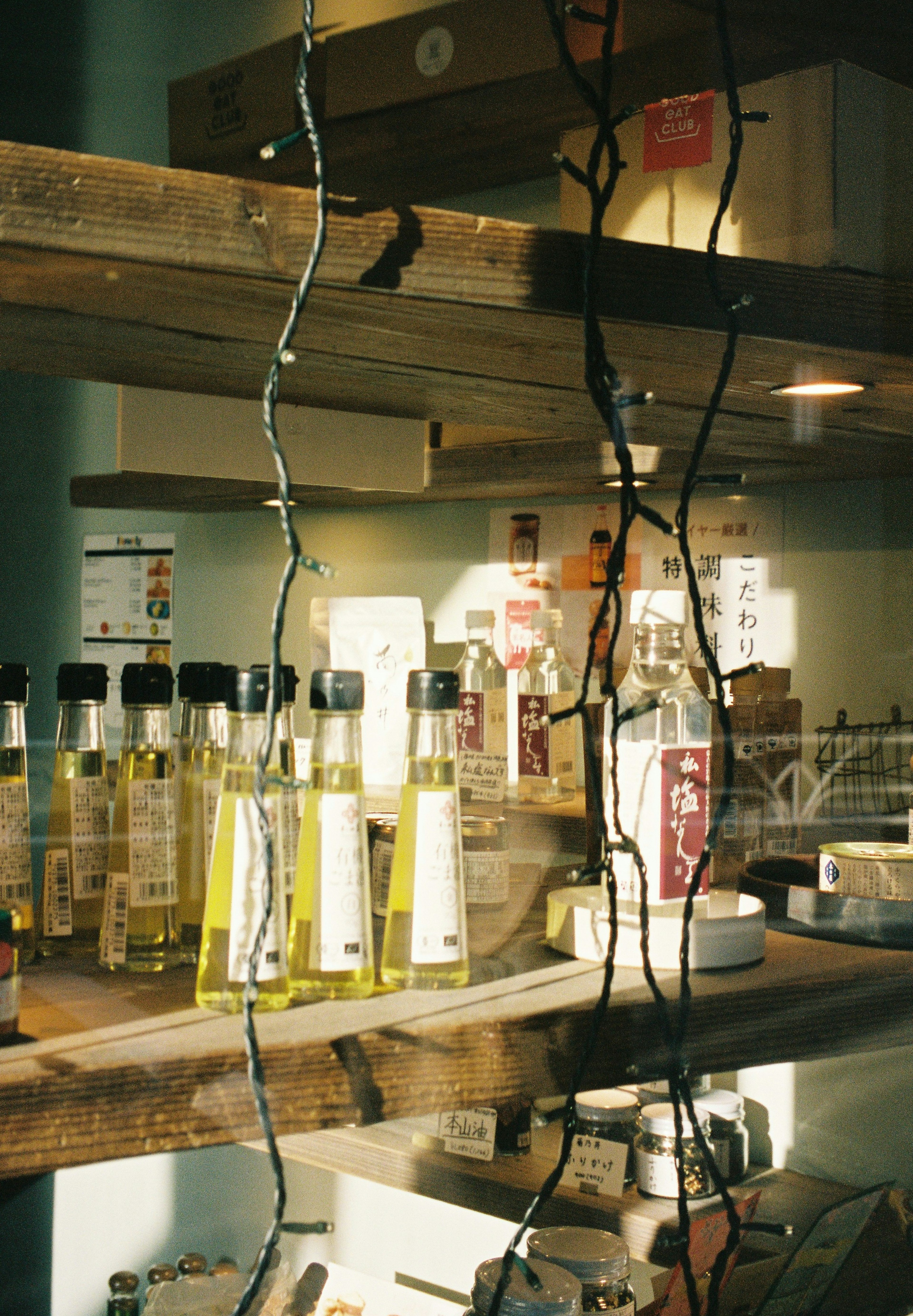 Bottles of olive oil lined on wooden shelves with string lights