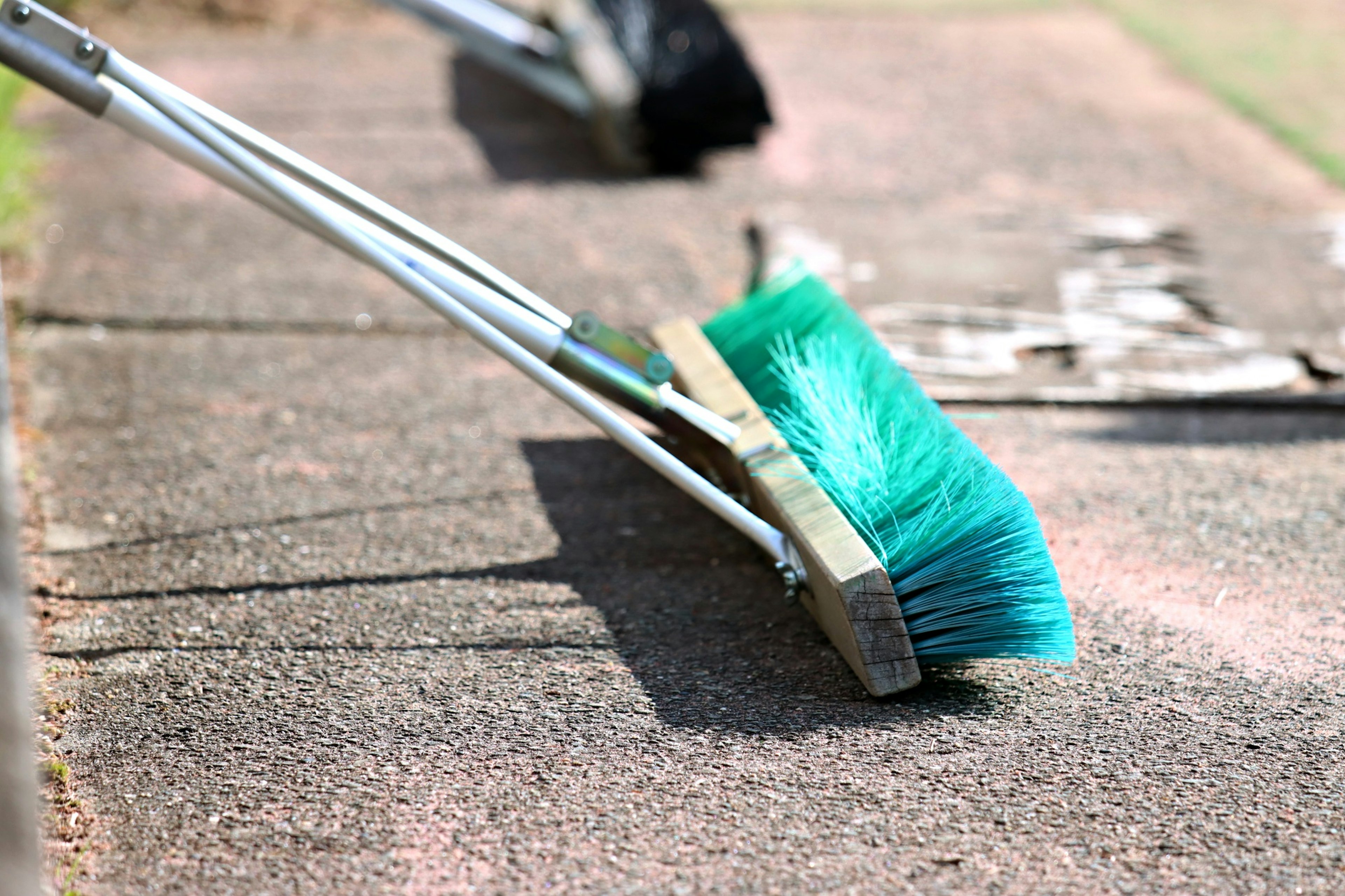 Una escoba azul barriendo el suelo