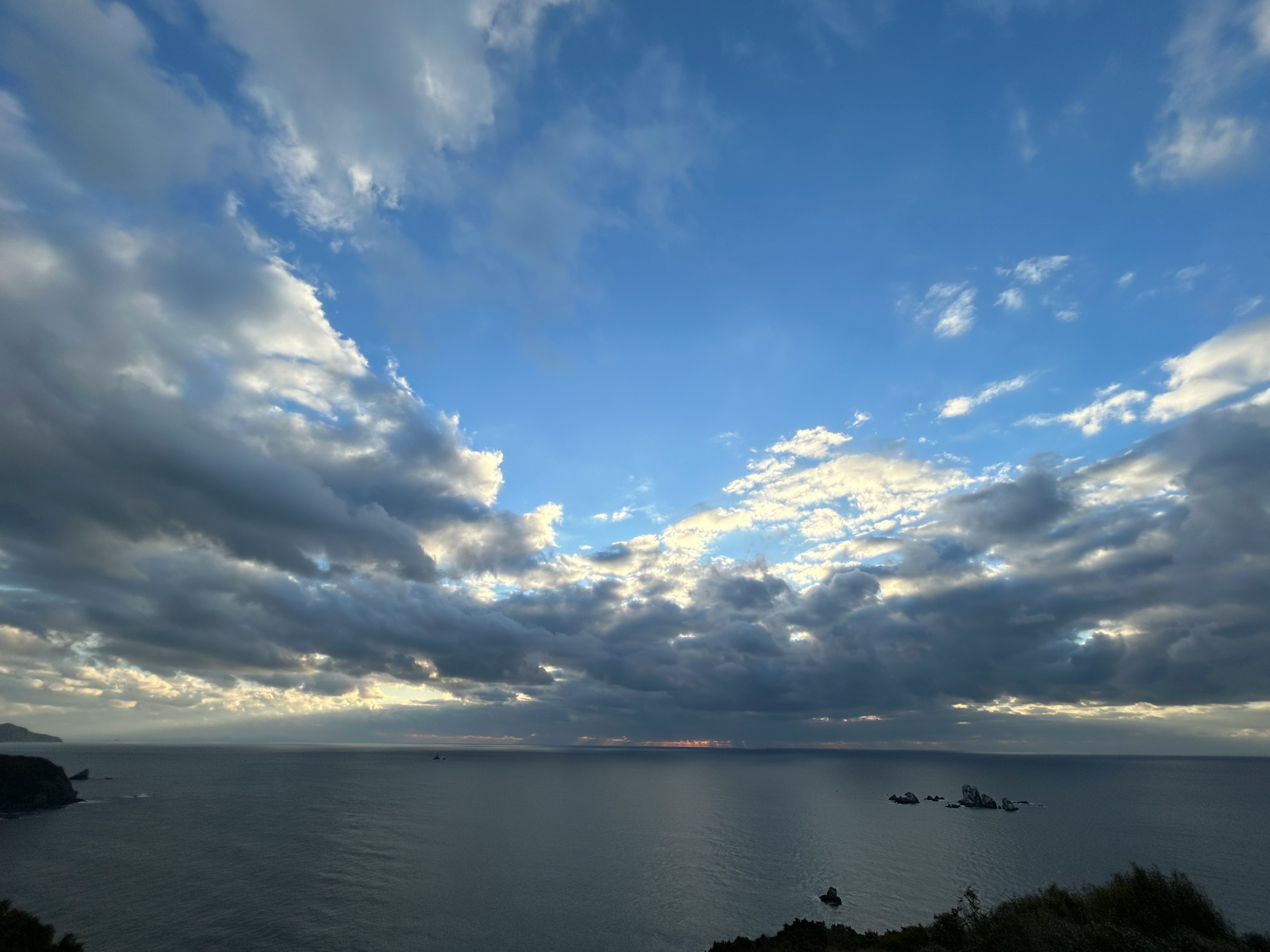 美麗的海洋和天空景觀，散佈著雲朵和寧靜的水面