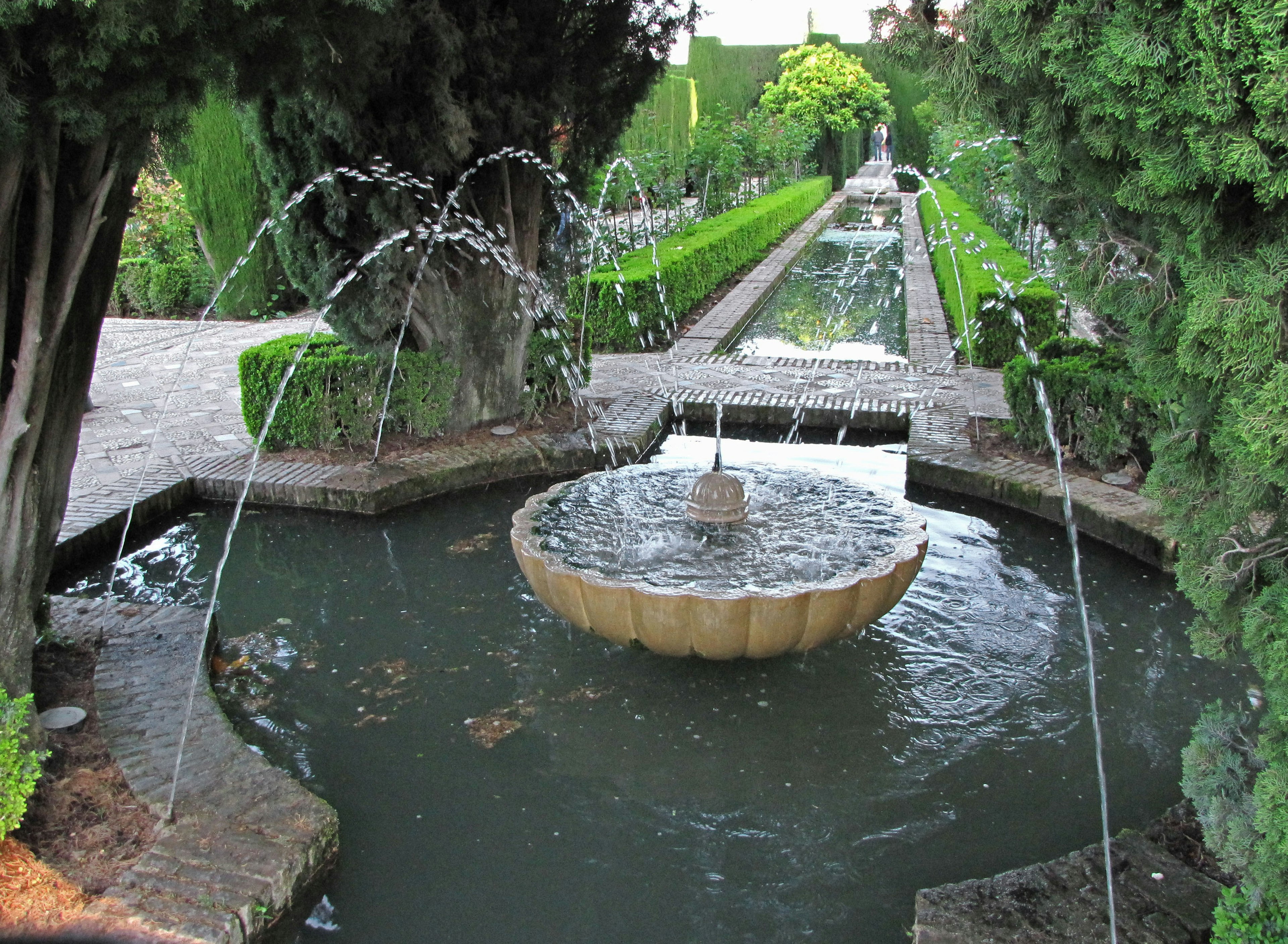 Eine malerische Aussicht mit einem Brunnen und fließendem Wasser in einem schönen Garten