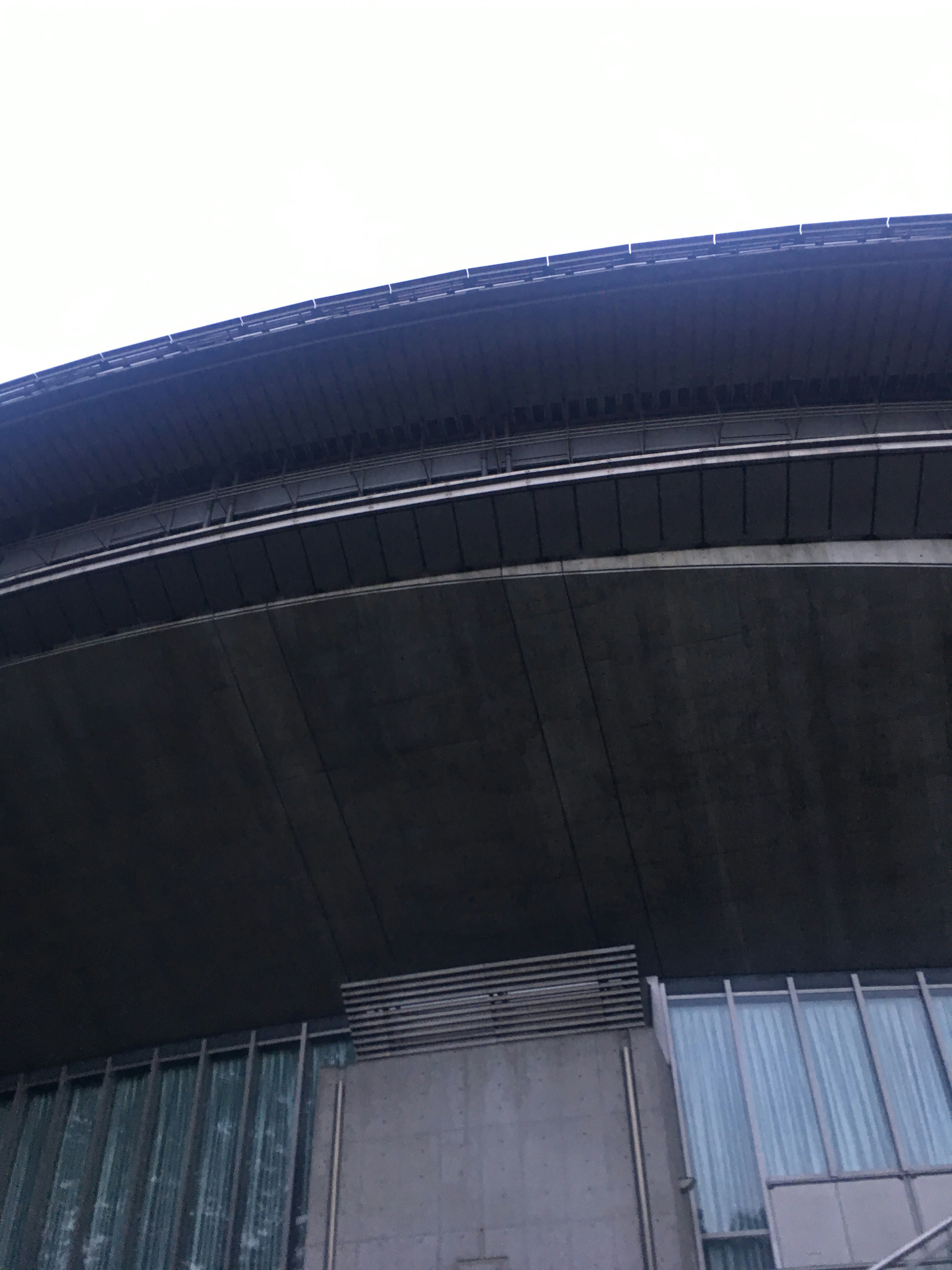 Curved roof of a building with glass facade