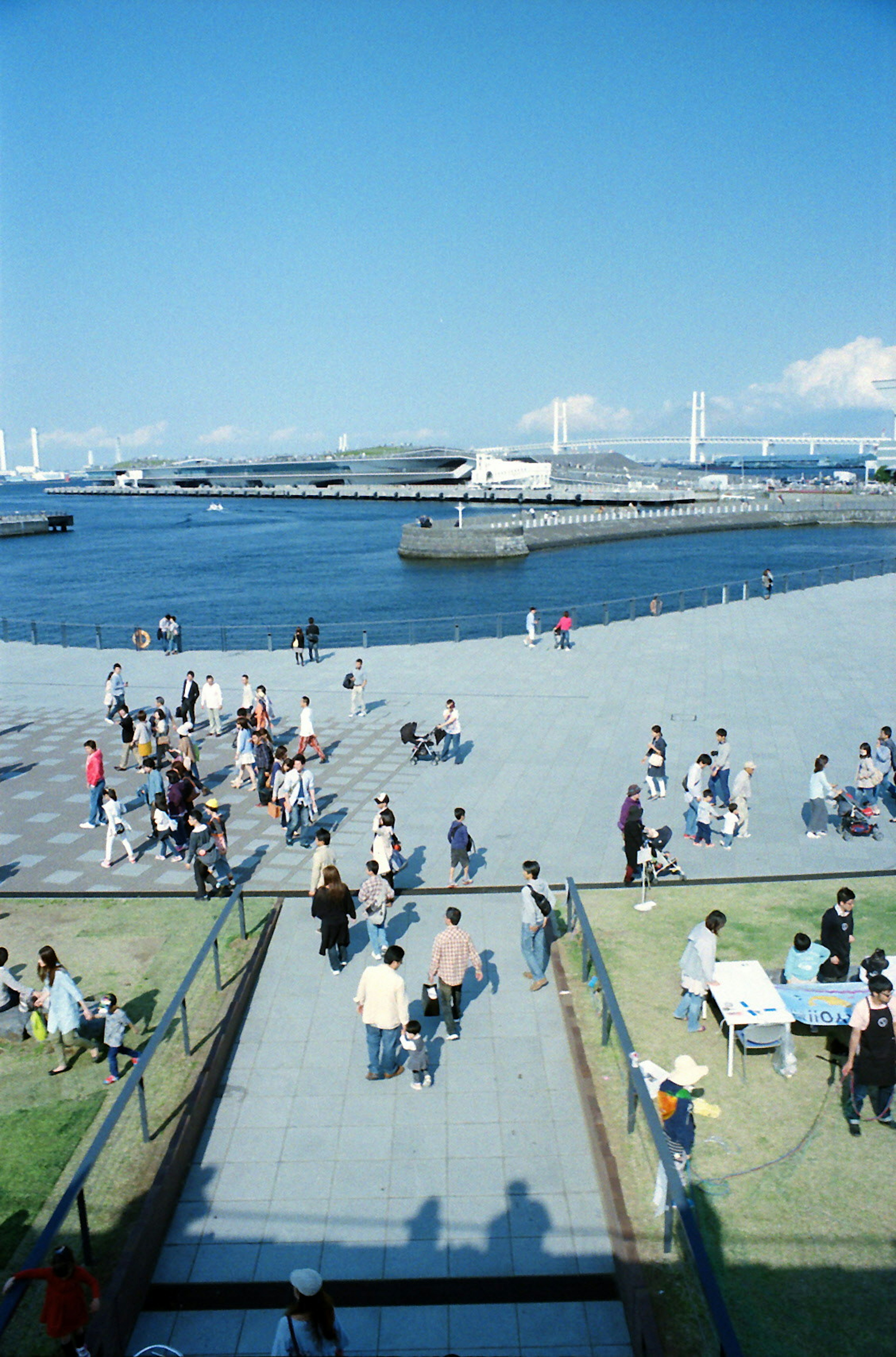 A coastal scene with people walking under a blue sky