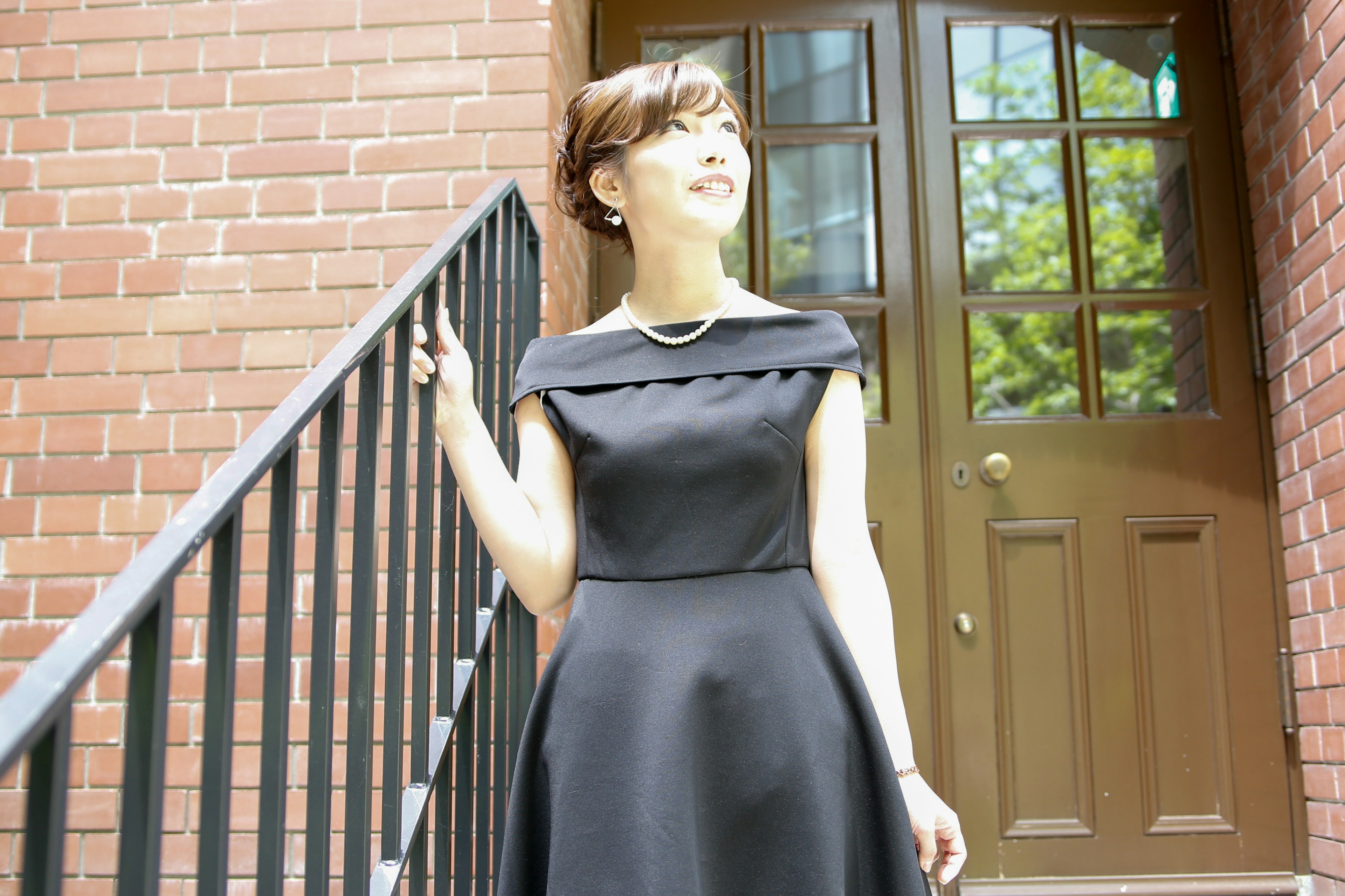 A woman in a black dress standing on stairs