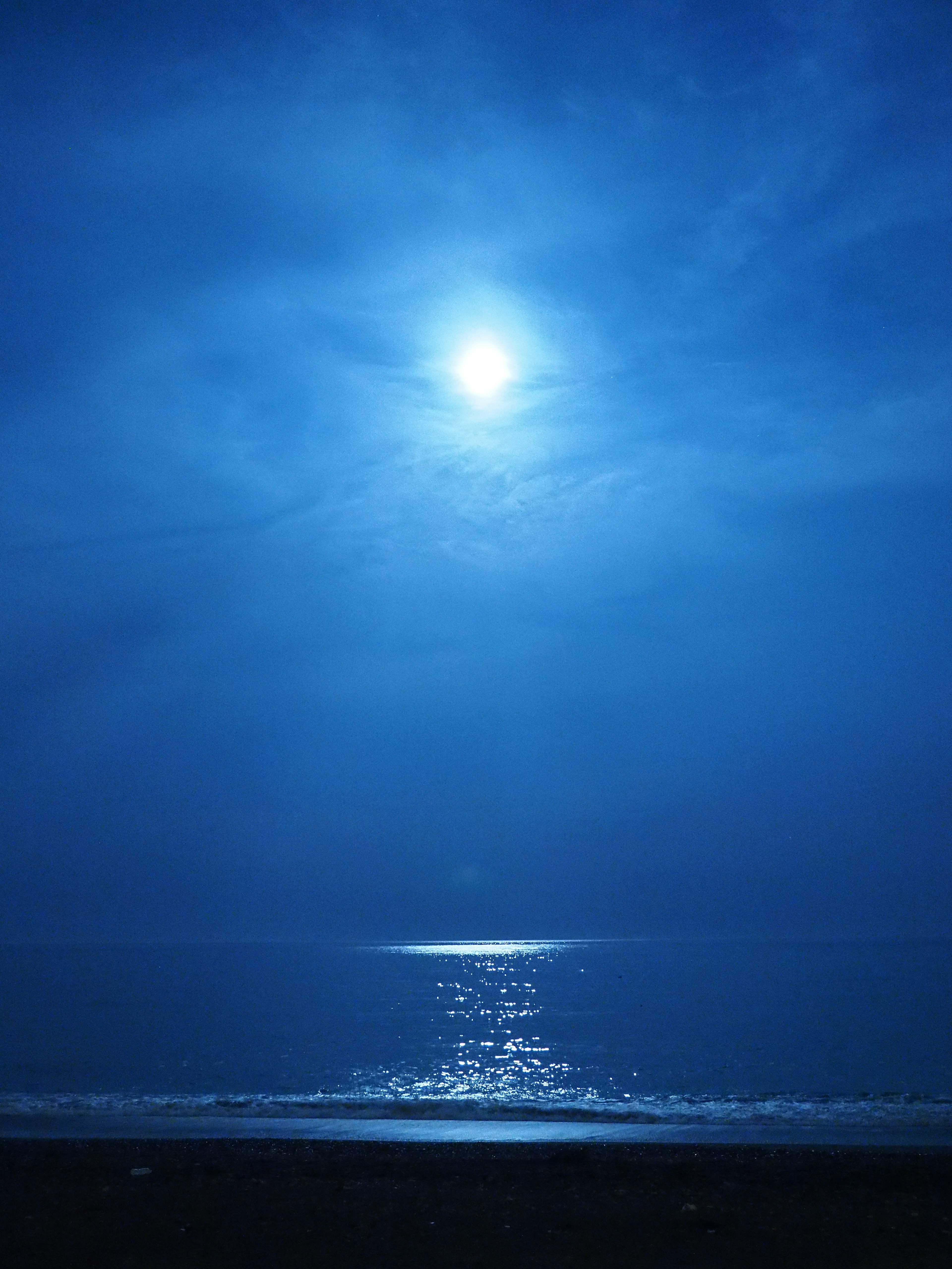 Una escena tranquila del océano azul reflejando la luz de la luna