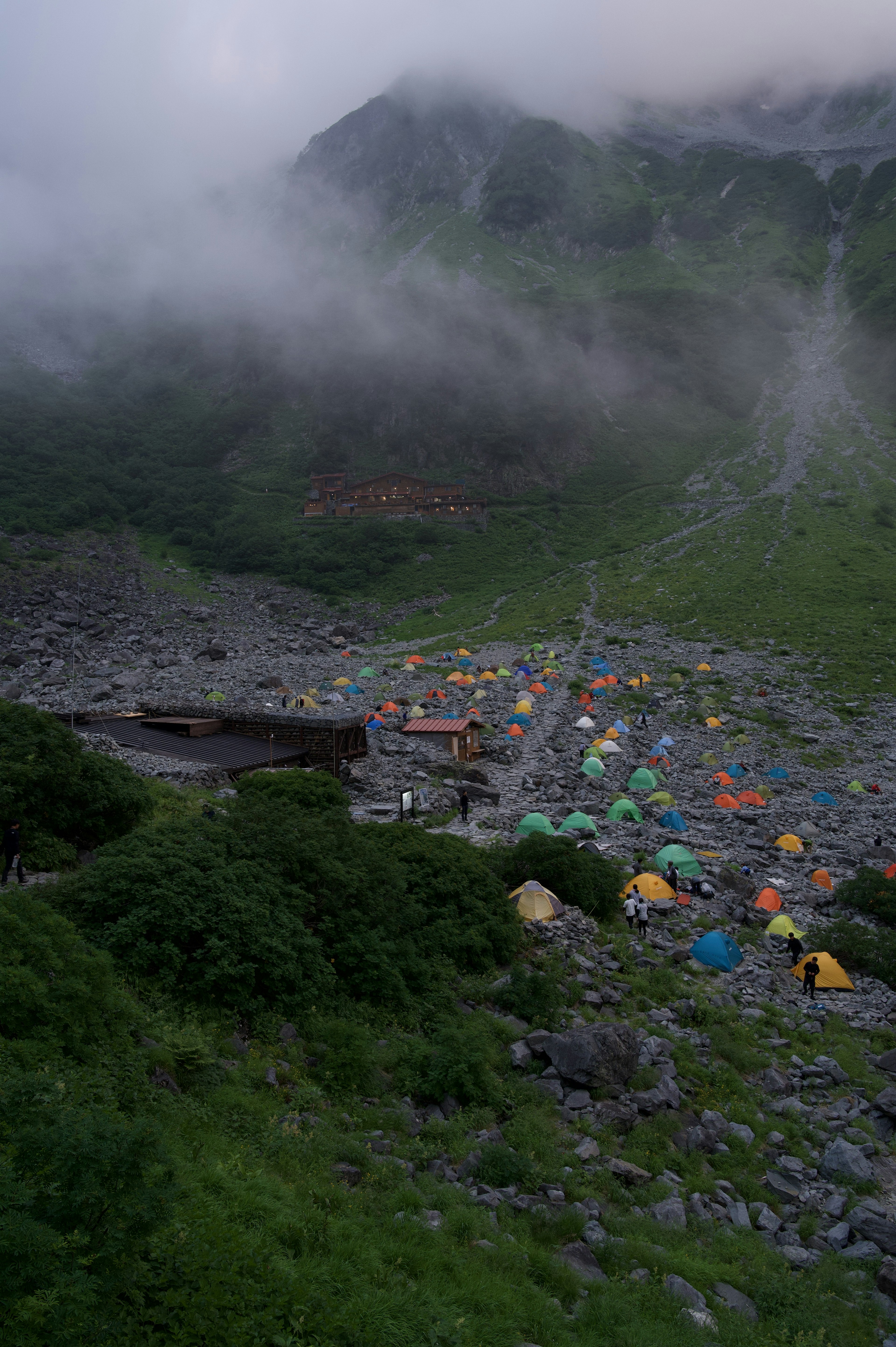 籠罩在霧中的山地營地 五彩斑斕的帳篷散落在景觀中