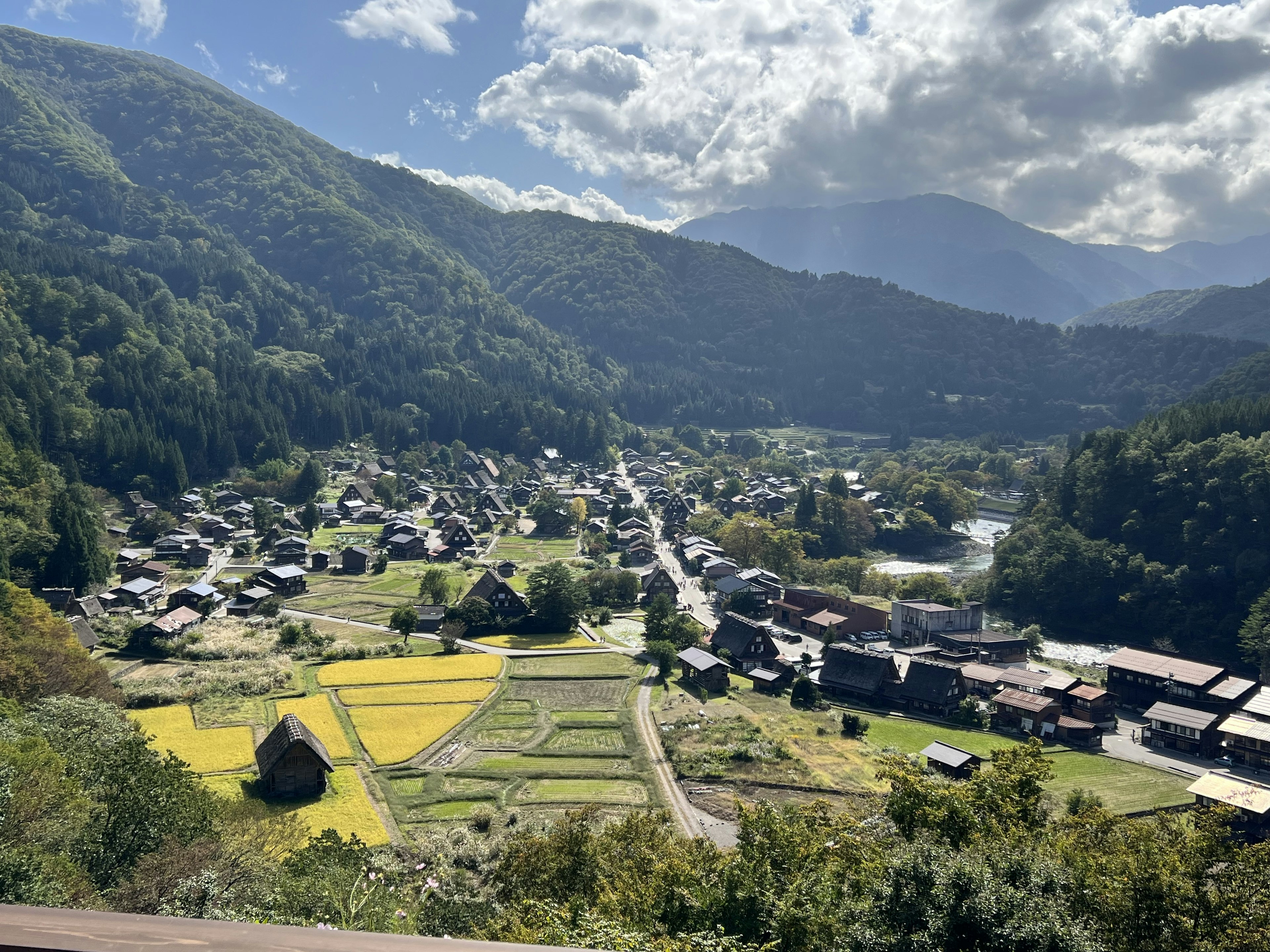 Vista panoramica di un villaggio tradizionale circondato da montagne con risaie