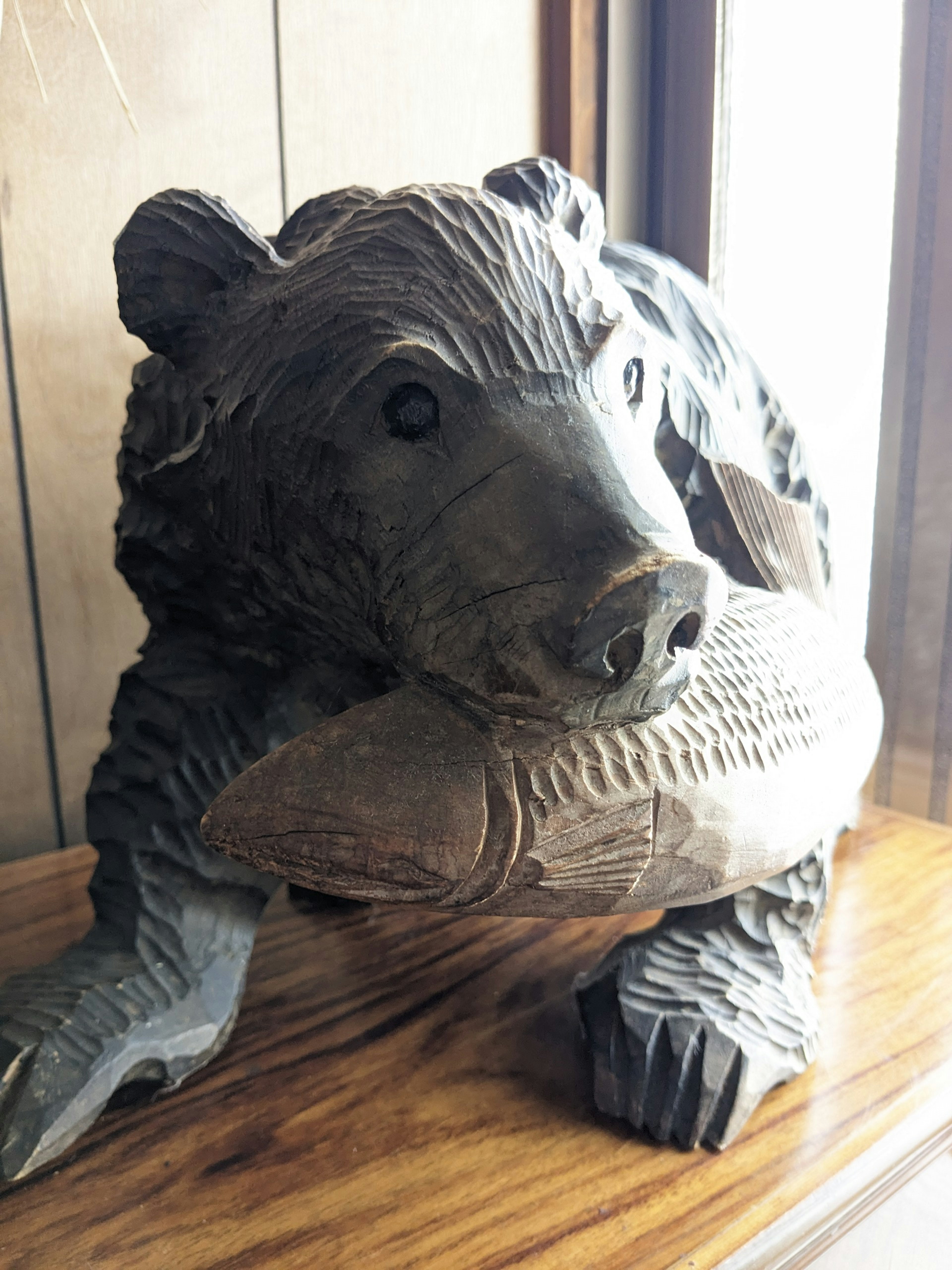 Escultura de madera de un oso sosteniendo un pez