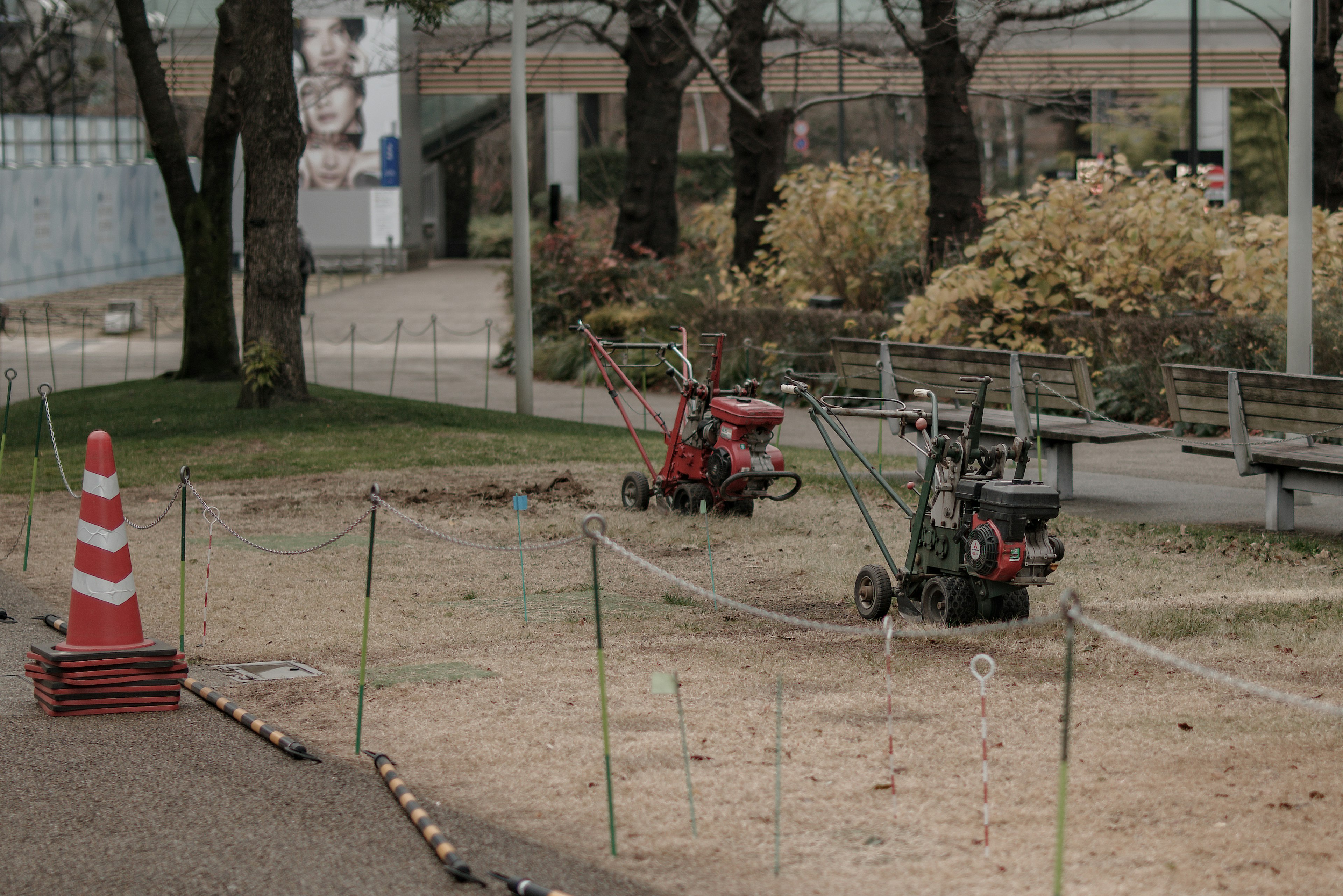 Parc en rénovation avec des machines rouges et vertes labourant le sol