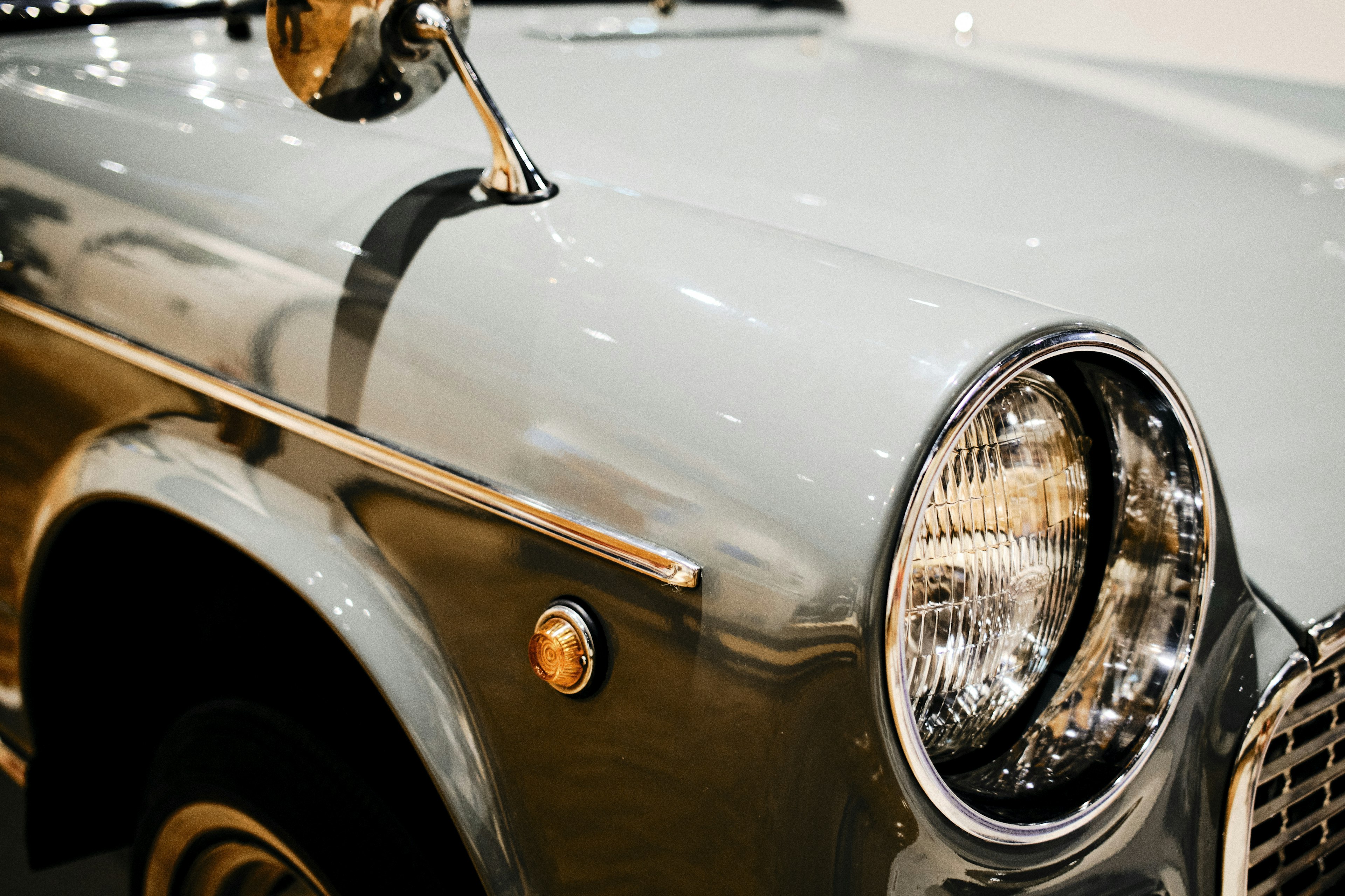 Close-up of a classic car front silver body and round headlights visible