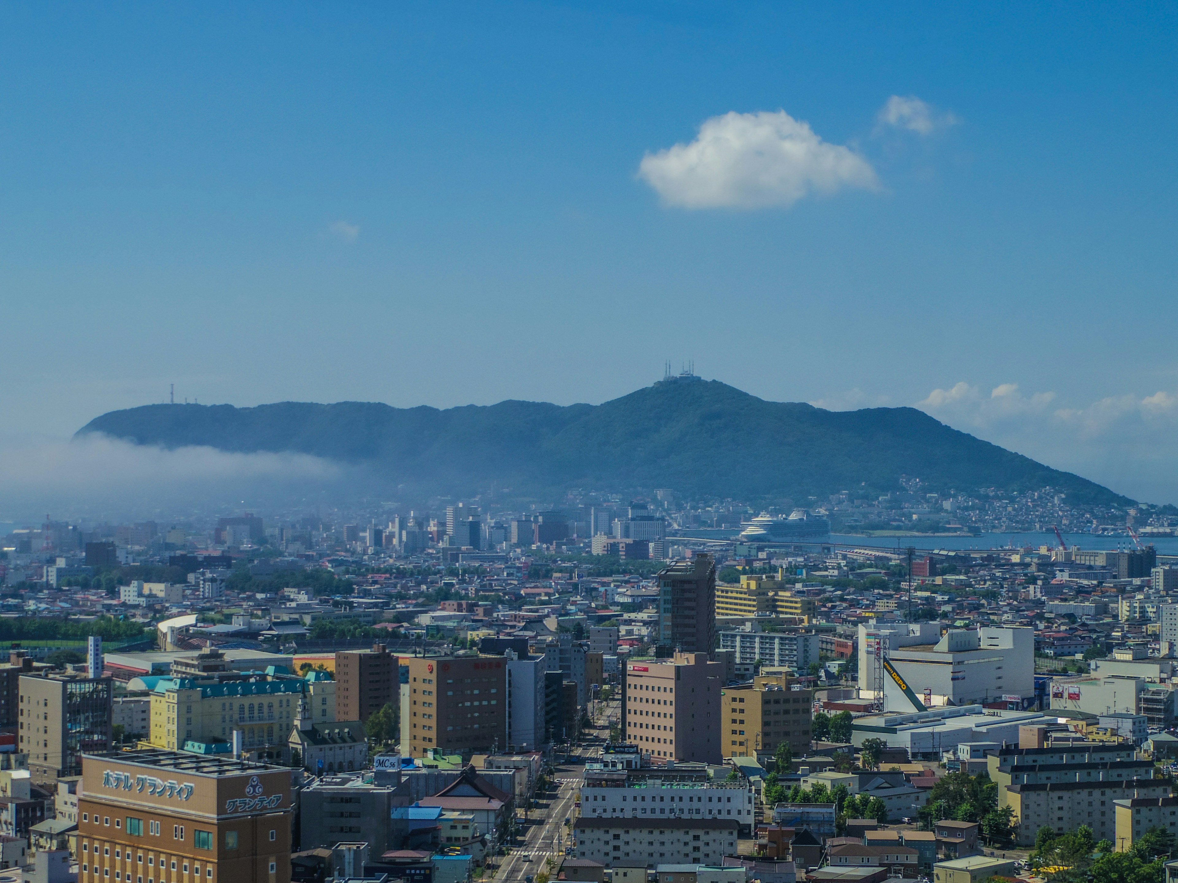 Vue panoramique d'une ville avec des montagnes et un ciel bleu clair