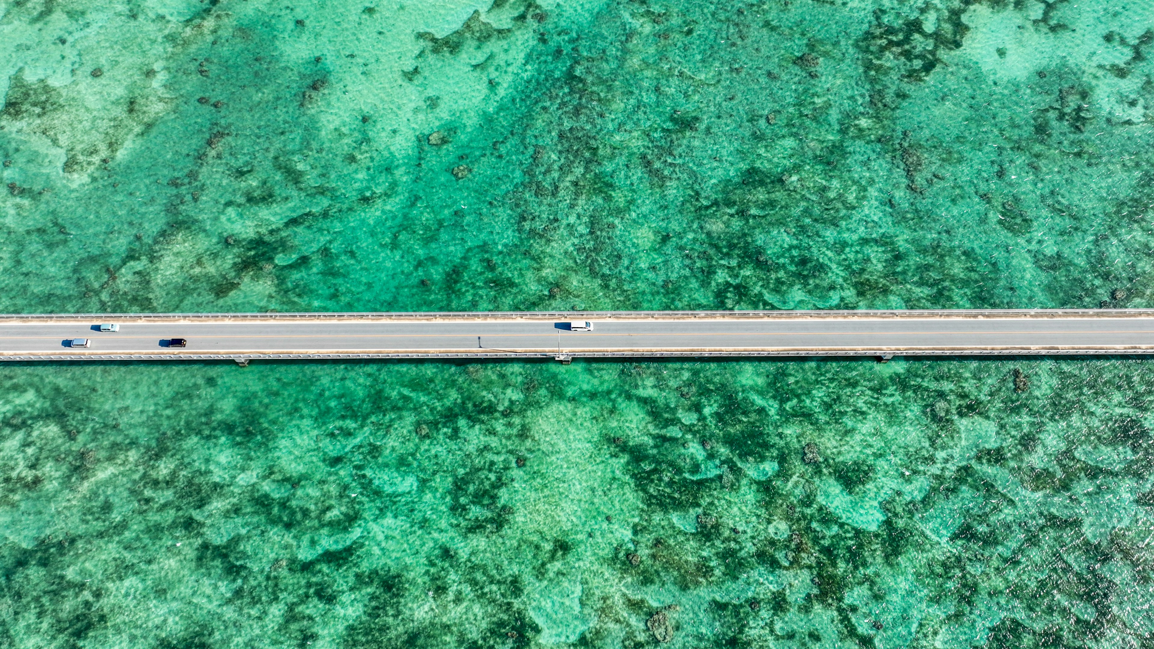 青い海に浮かぶ道路の上空からの視点