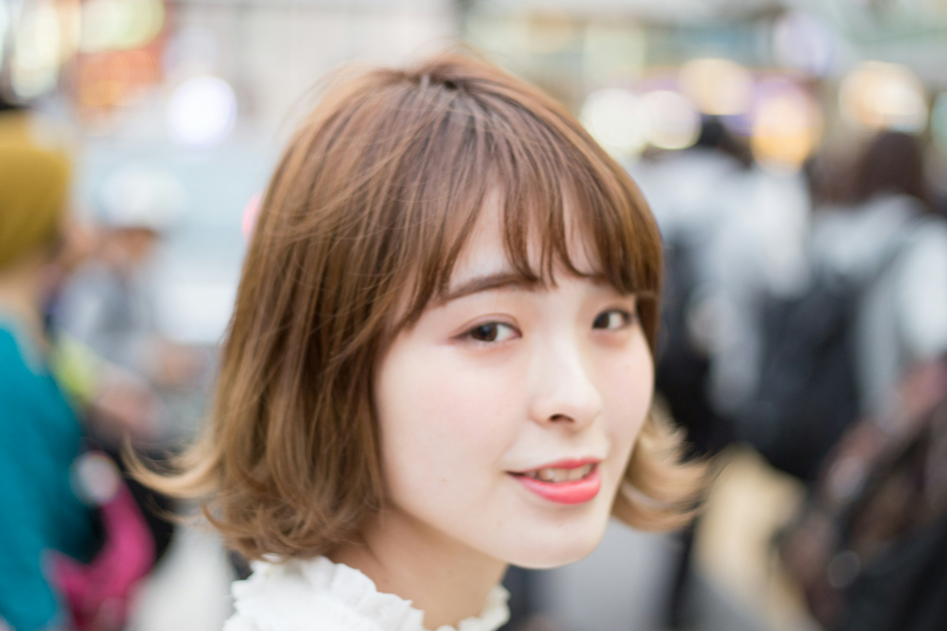 Portrait d'une jeune femme souriante dans la rue Coiffure courte blouse blanche