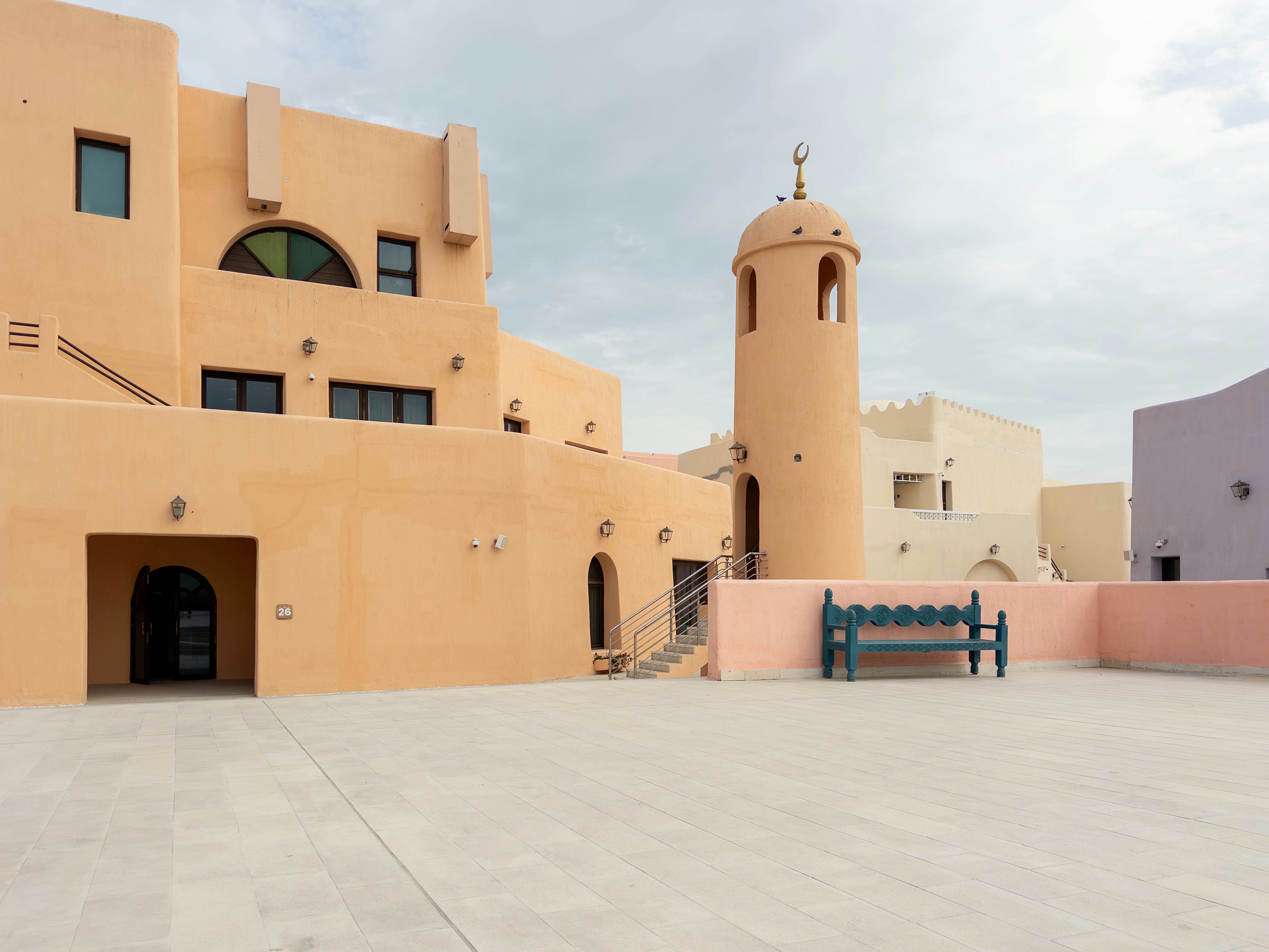 Plaza con edificios de colores claros y una torre