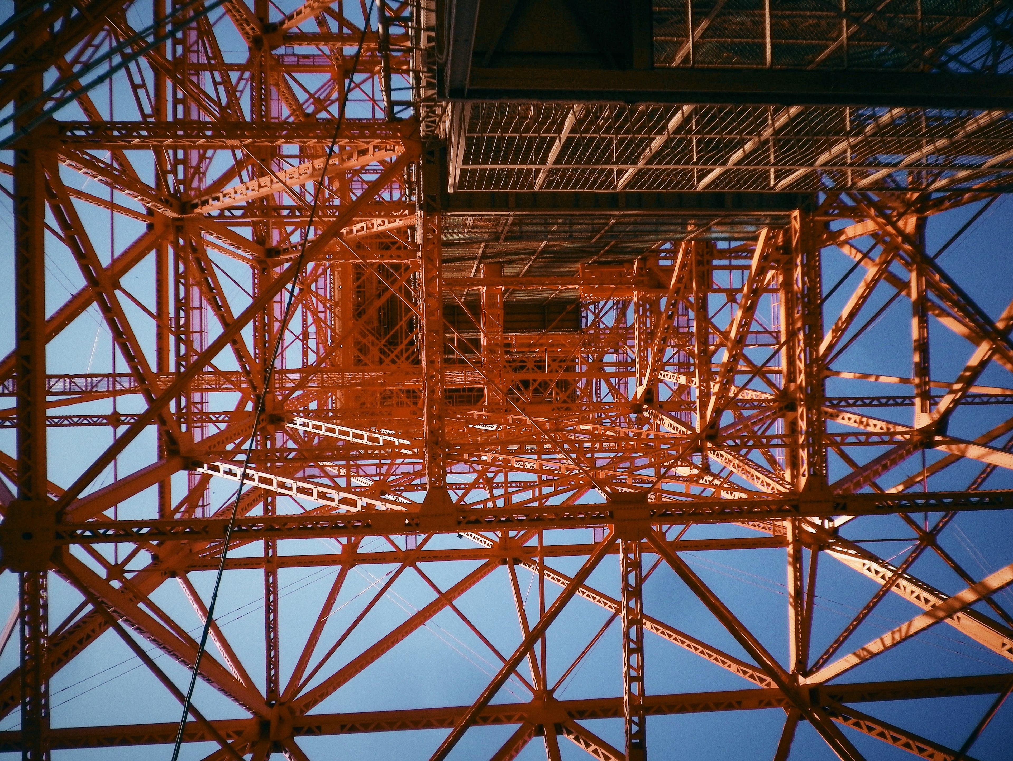 Vista detallada de la estructura de la Torre de Tokio mirando hacia arriba con marco de metal naranja