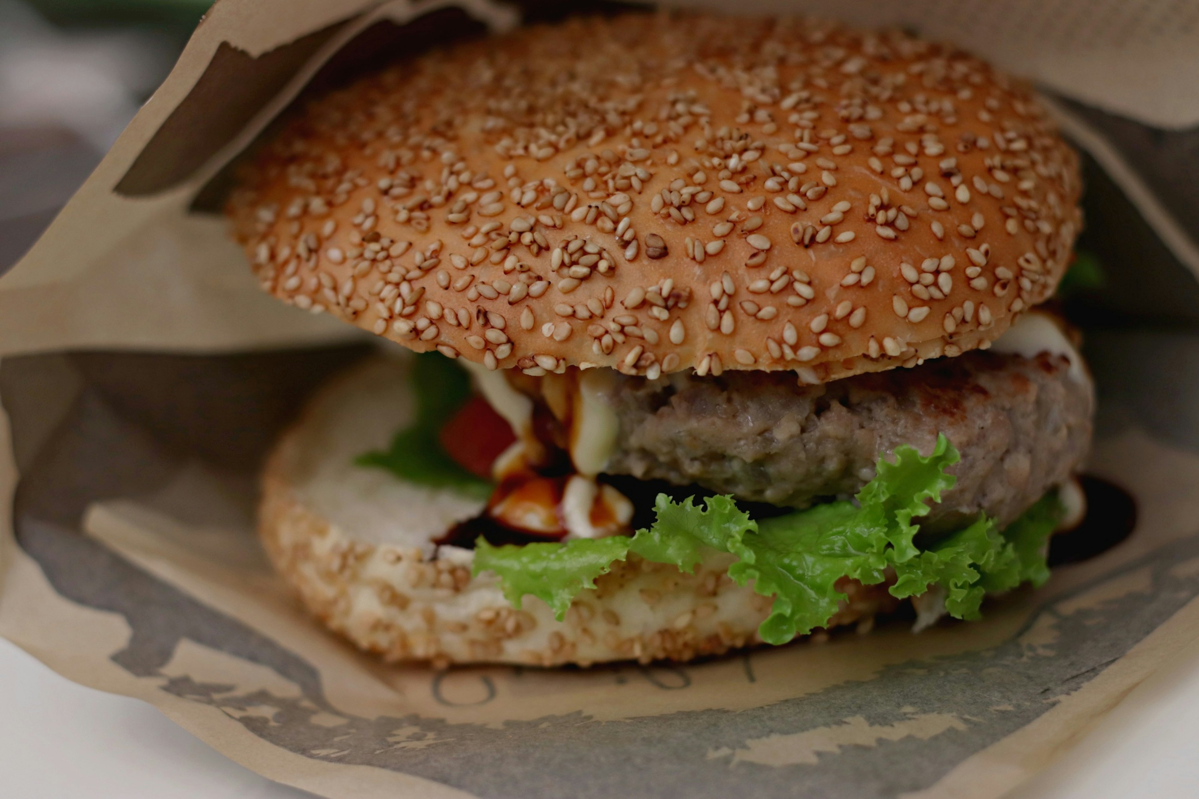 Sesame-seeded hamburger with fresh lettuce and tomato visible