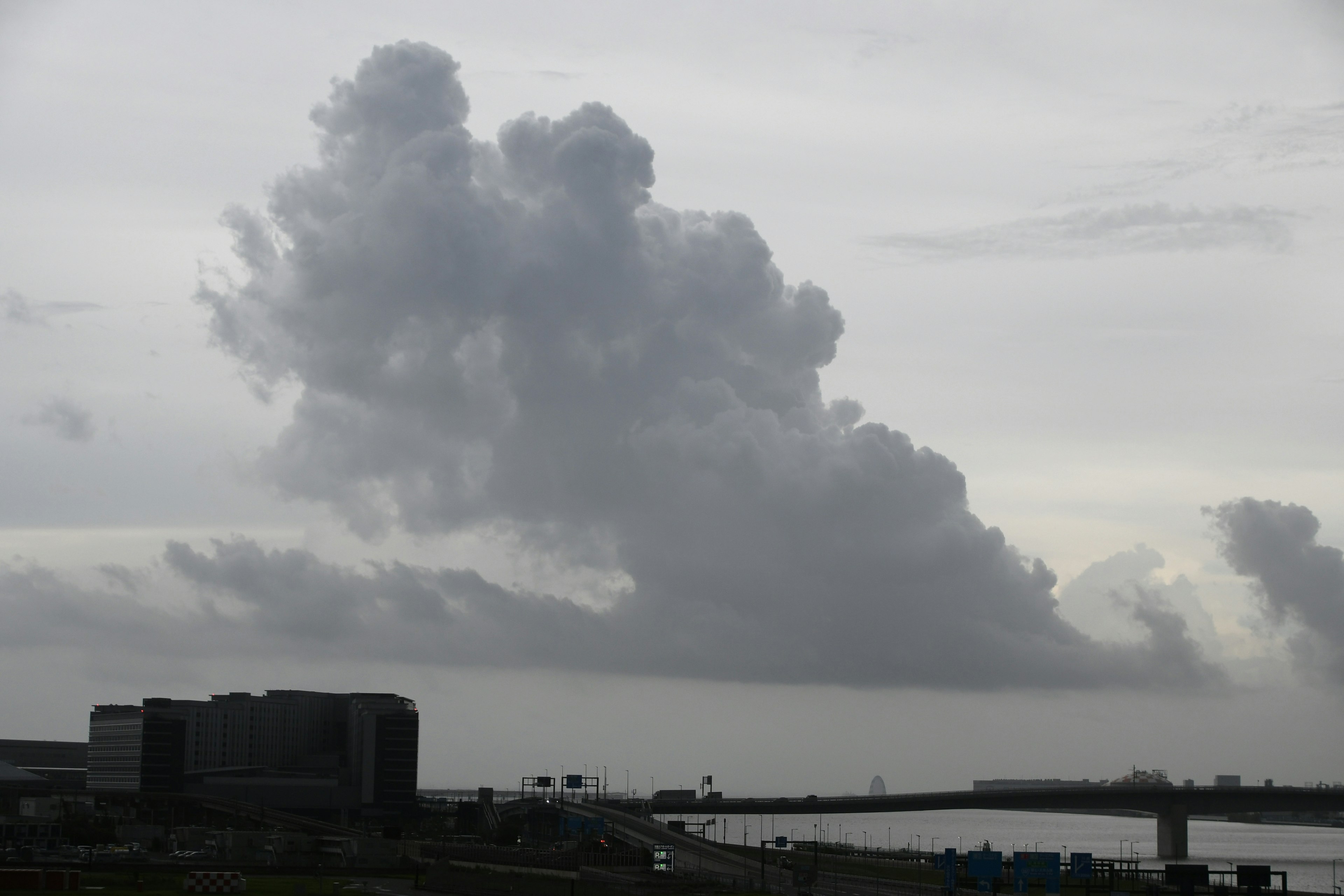 Gray sky with large clouds over a waterfront scene