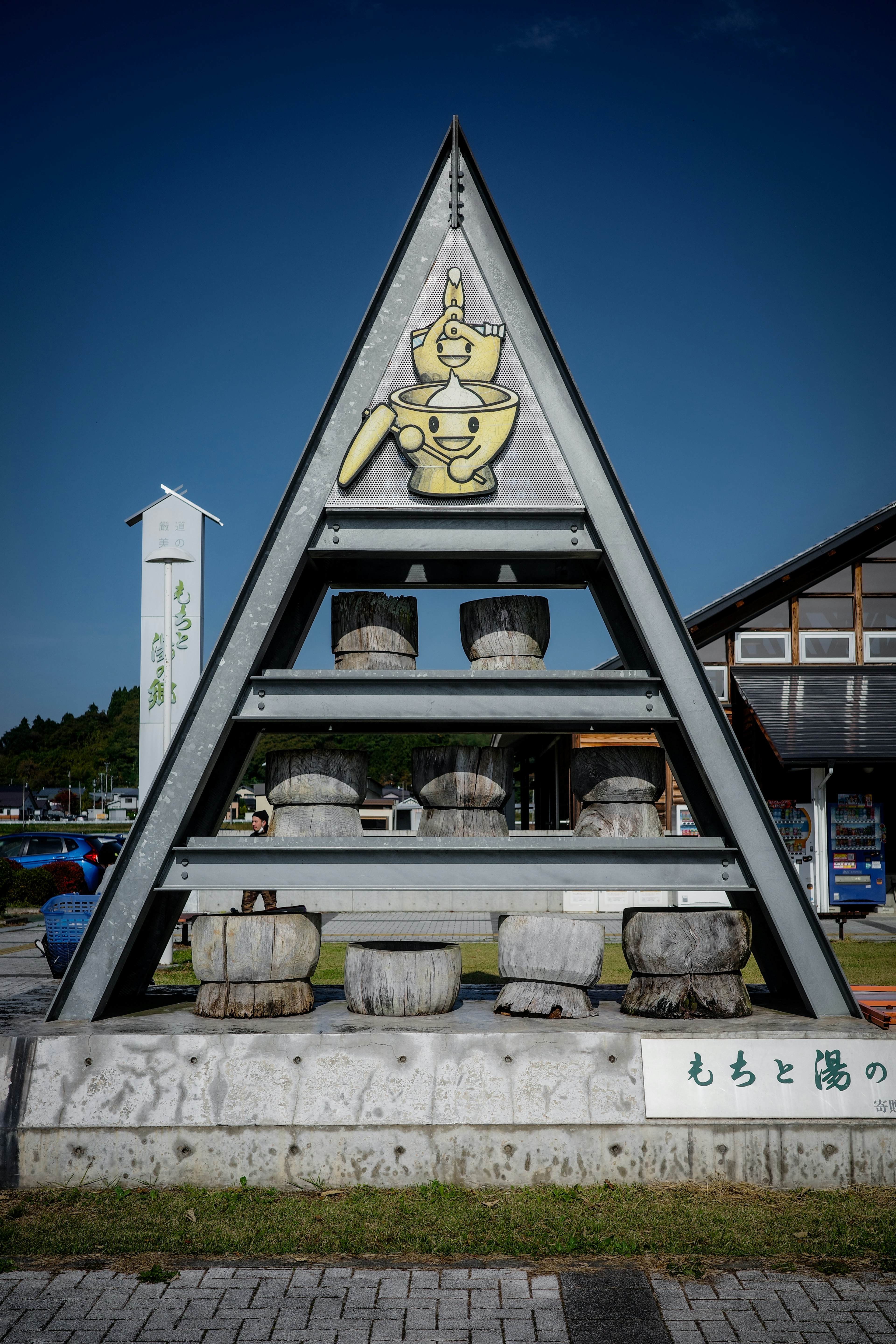 Triangular monument displaying multiple jars and a symbolic emblem