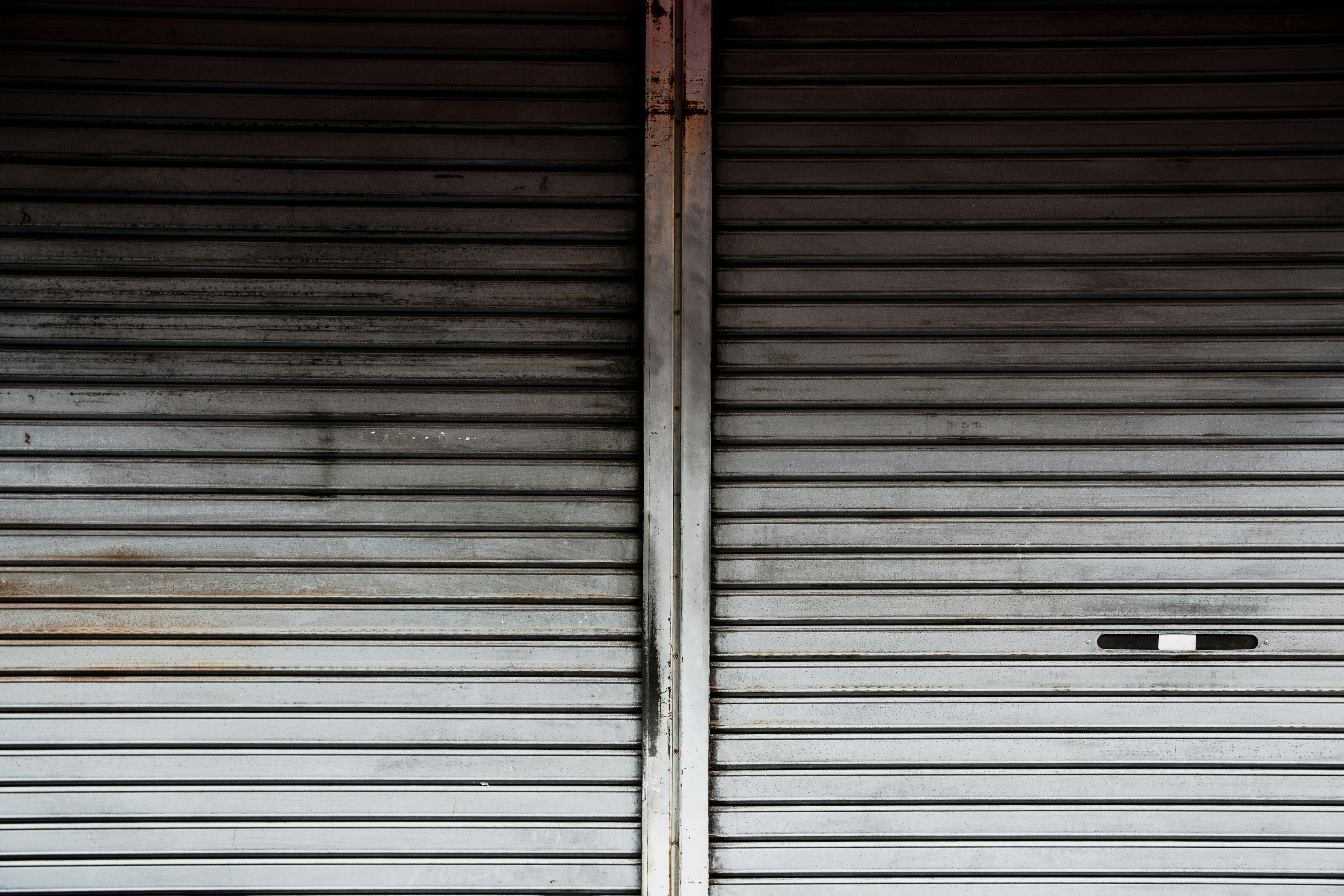 Image of closed metal shutters featuring gray stripes