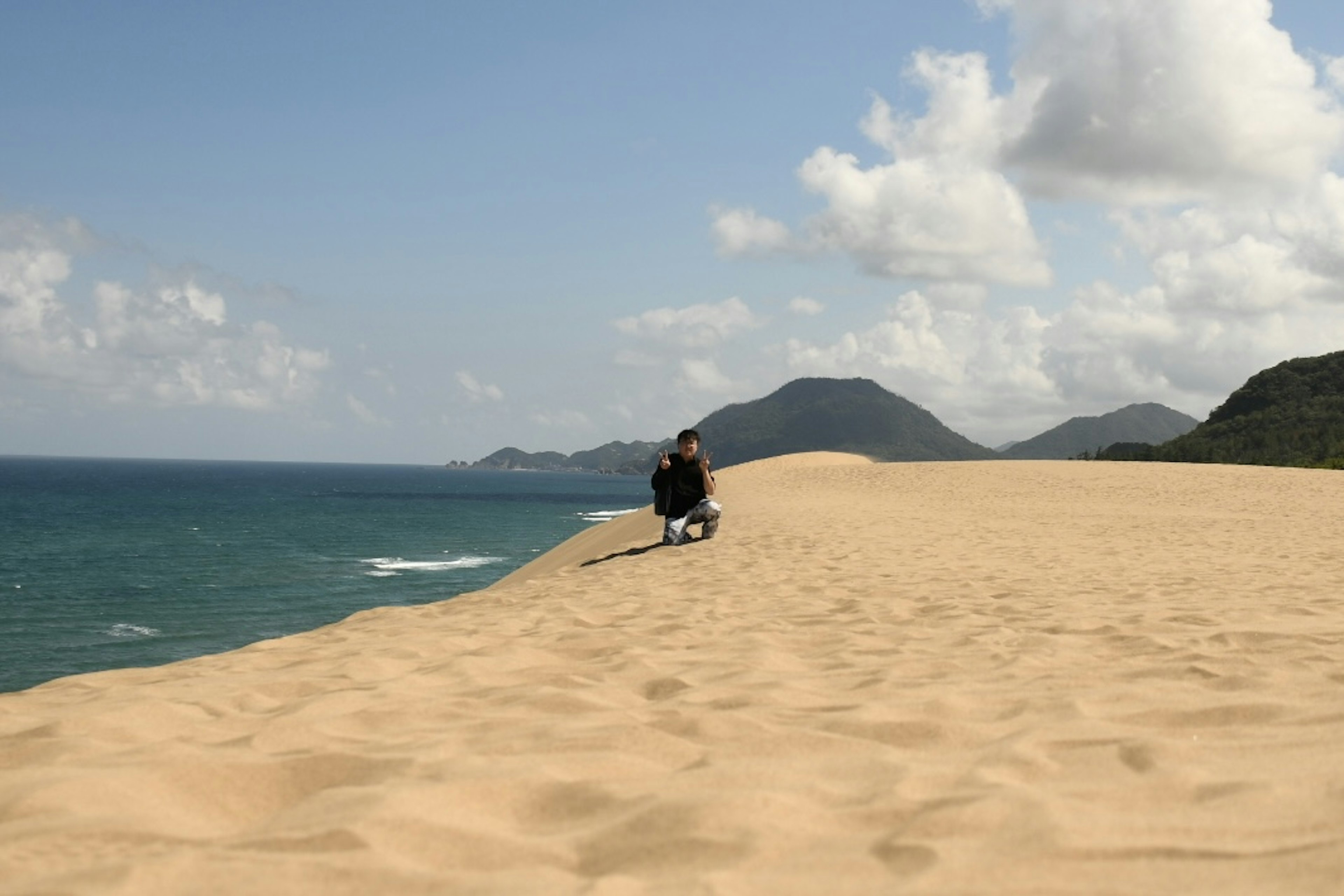 砂丘と海を背景にした人物のシルエット