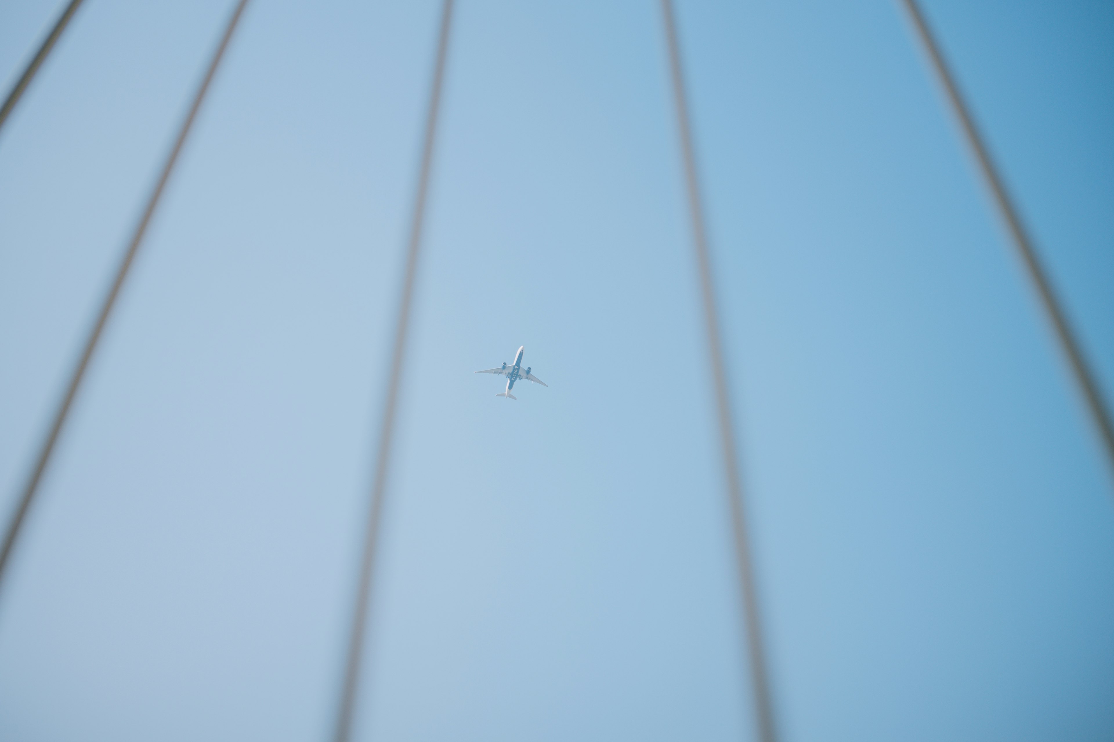 Imagen de un pequeño avión en el cielo azul con líneas delgadas de fondo