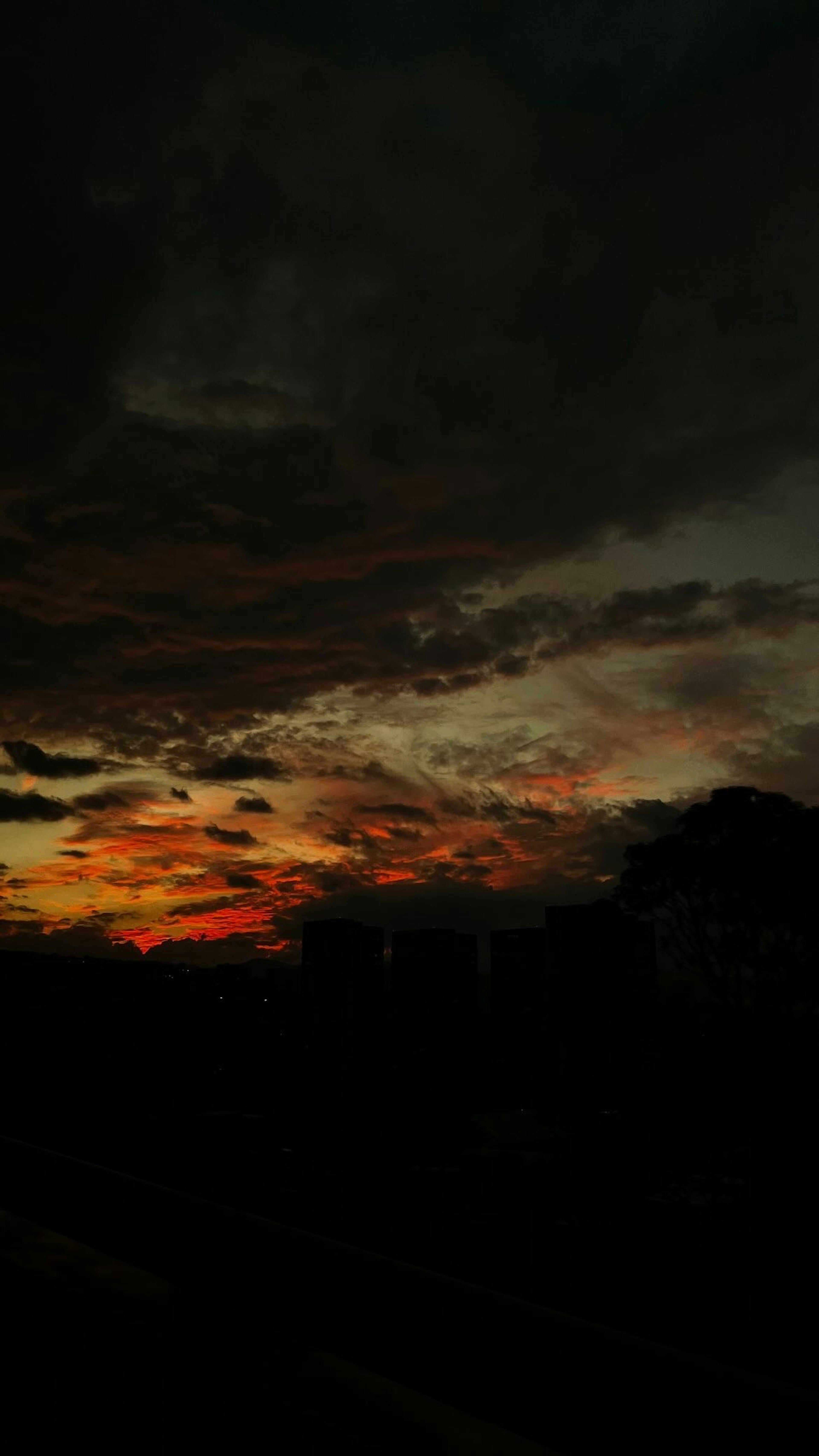 Vista panoramica di un tramonto con colori vivaci e nuvole scure