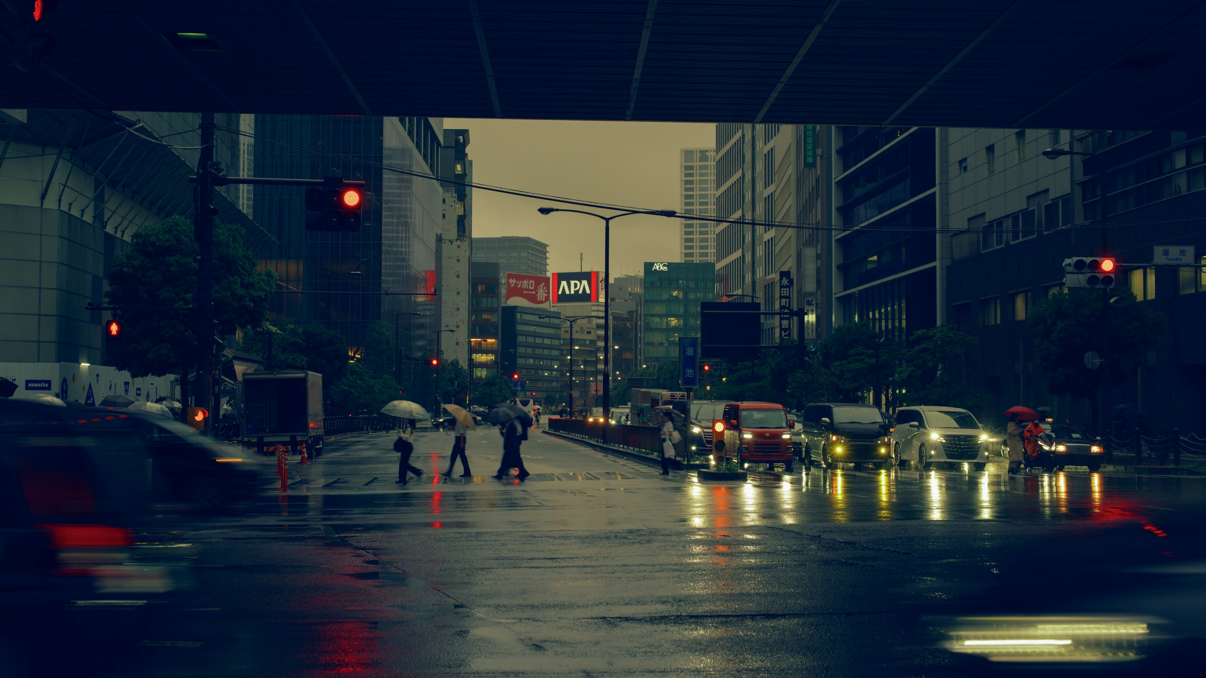 Escena urbana bajo la lluvia con peatones cruzando la calle