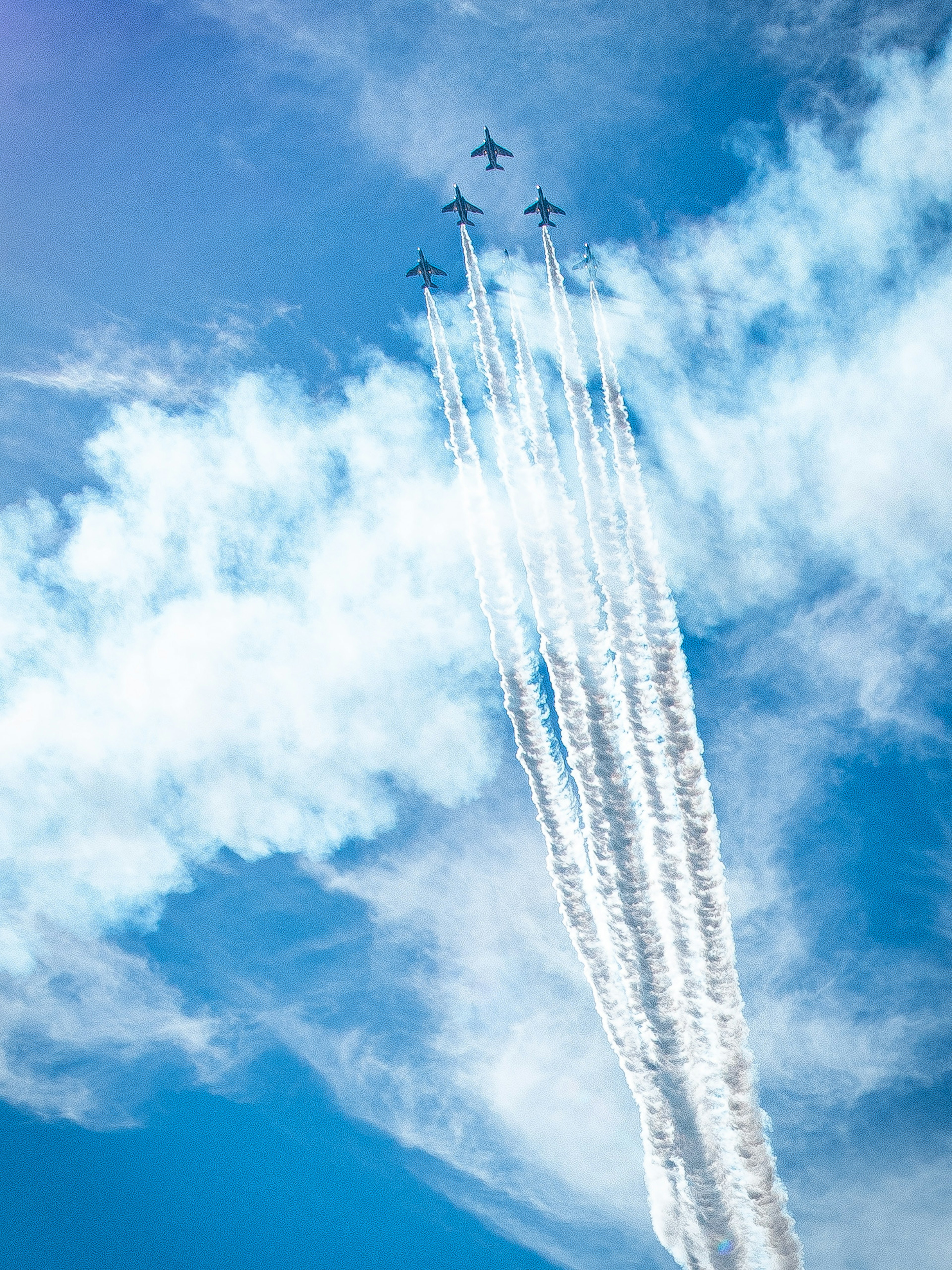 Avions en formation laissant des traînées de vapeur dans un ciel bleu