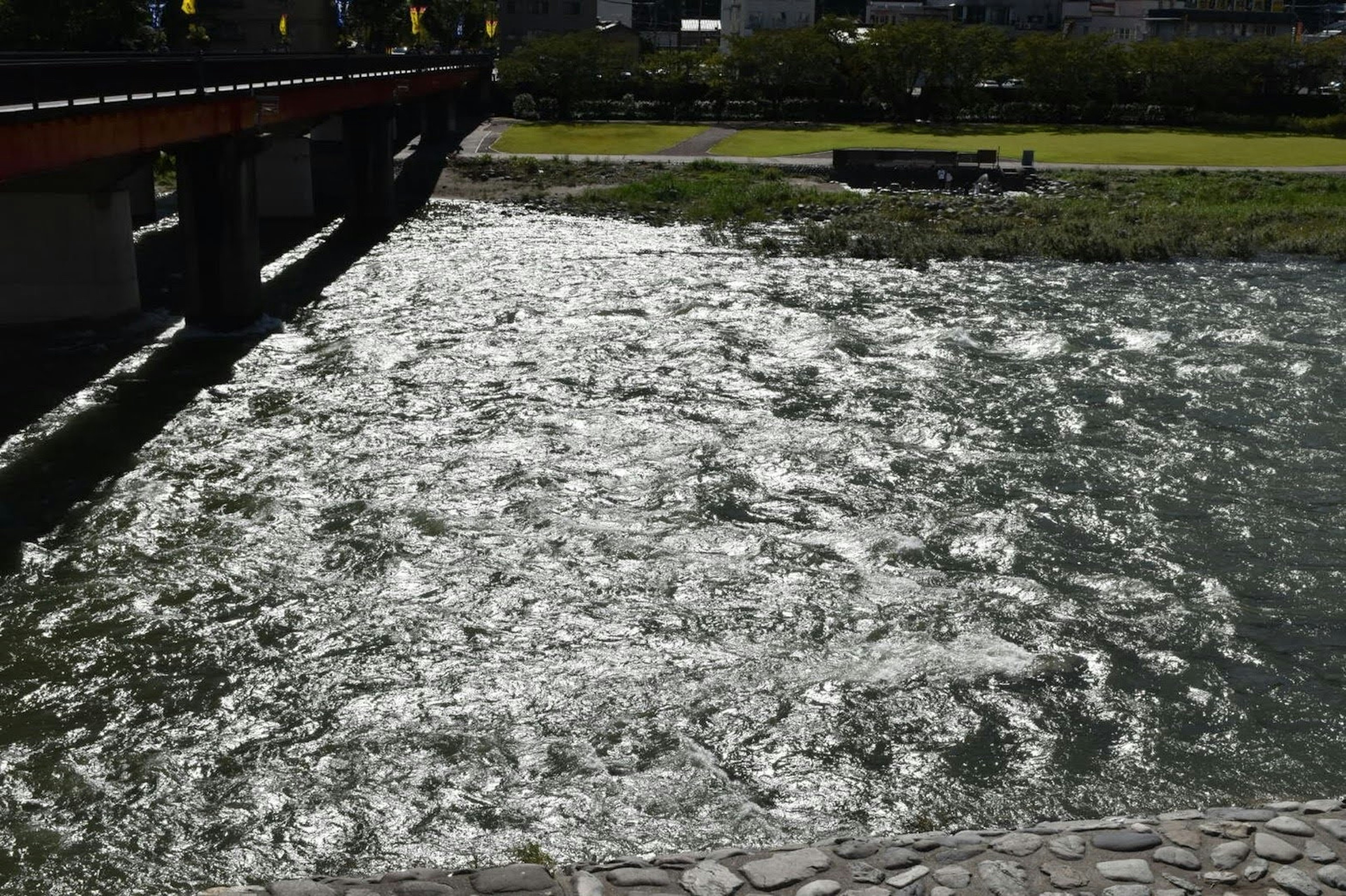 Reflective river surface with part of a bridge