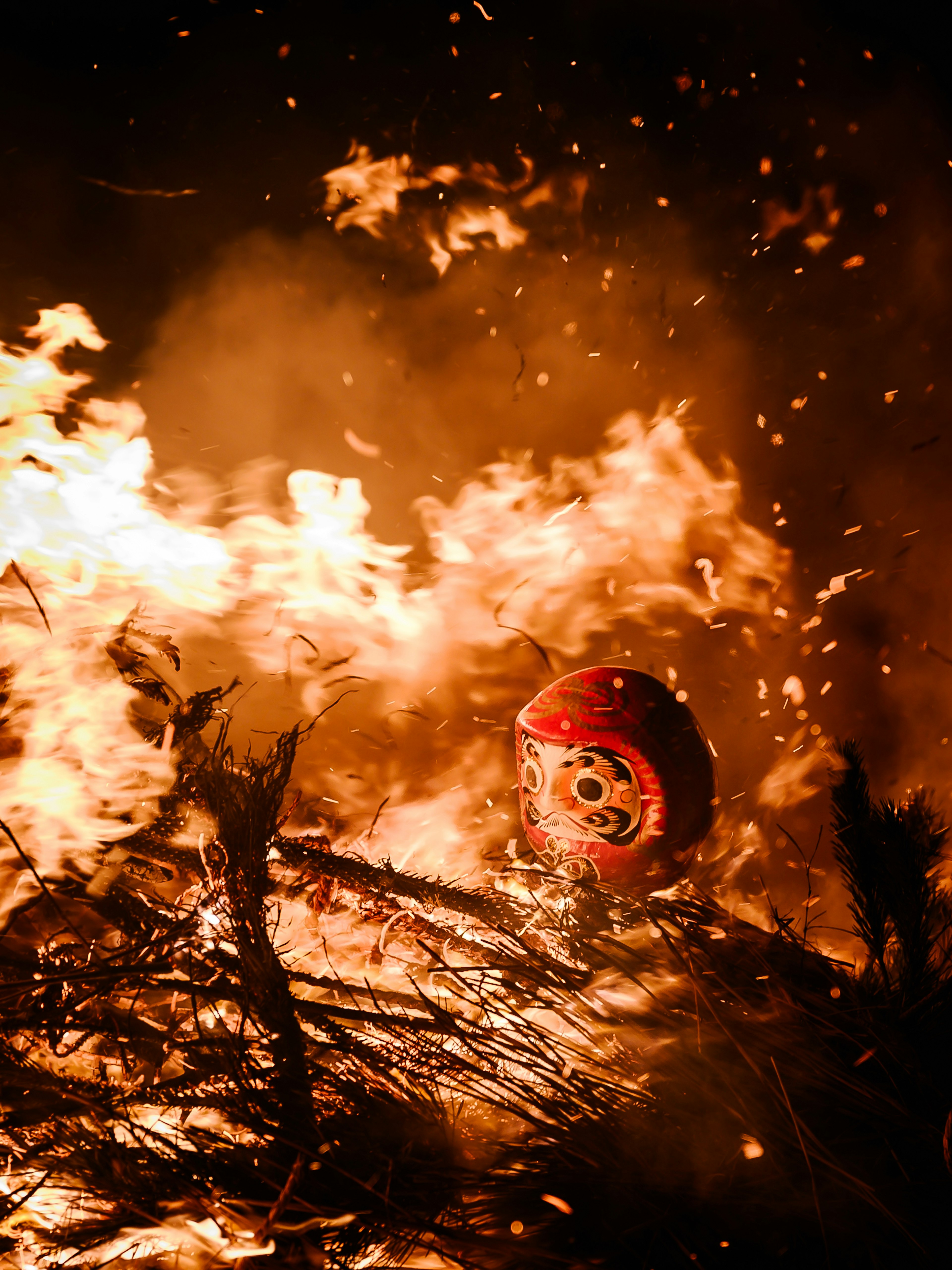 Objeto rojo envuelto en llamas con ramas ardiendo