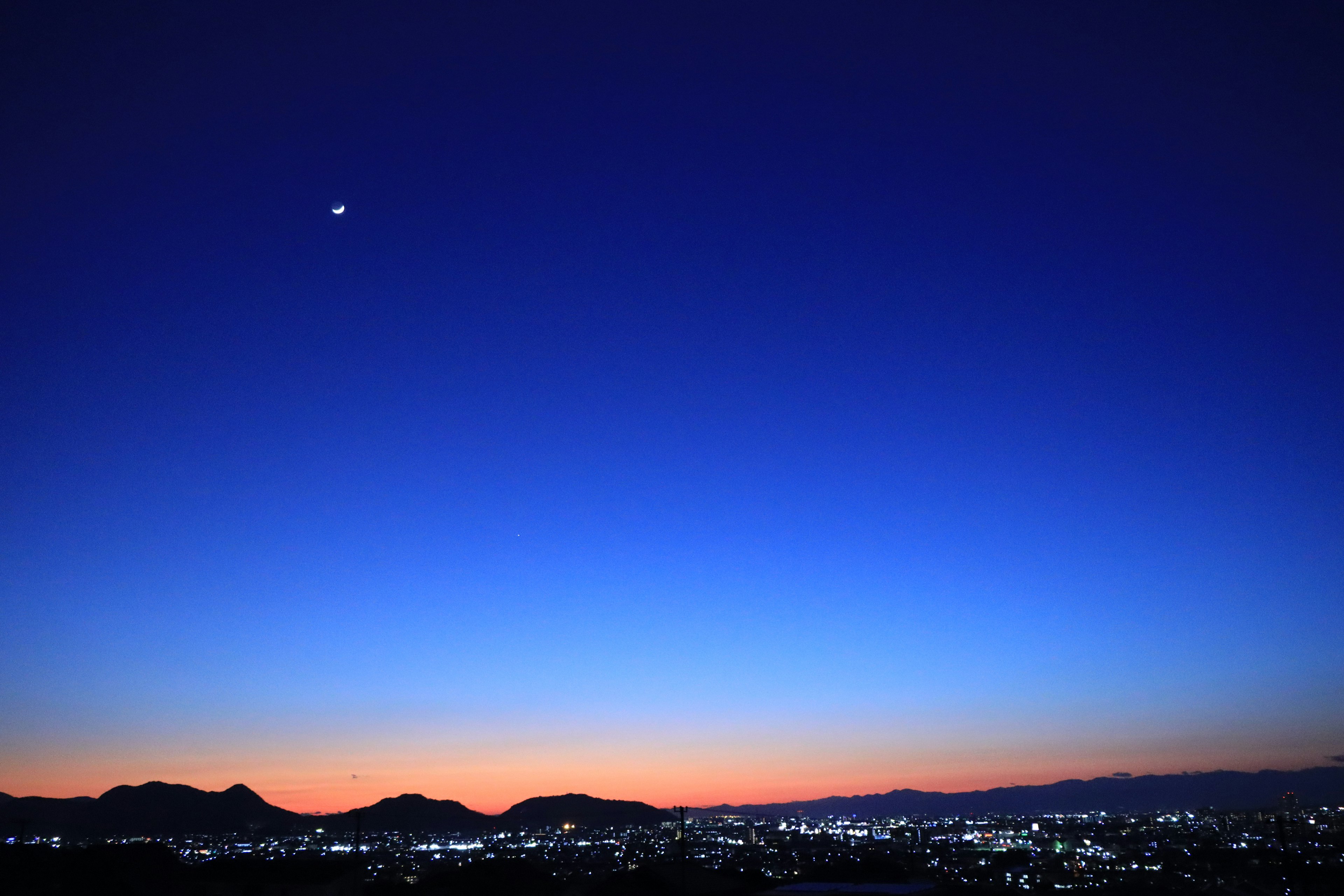 Cielo a gradiente mozzafiato con tonalità blu e arancioni al tramonto con una stella luminosa