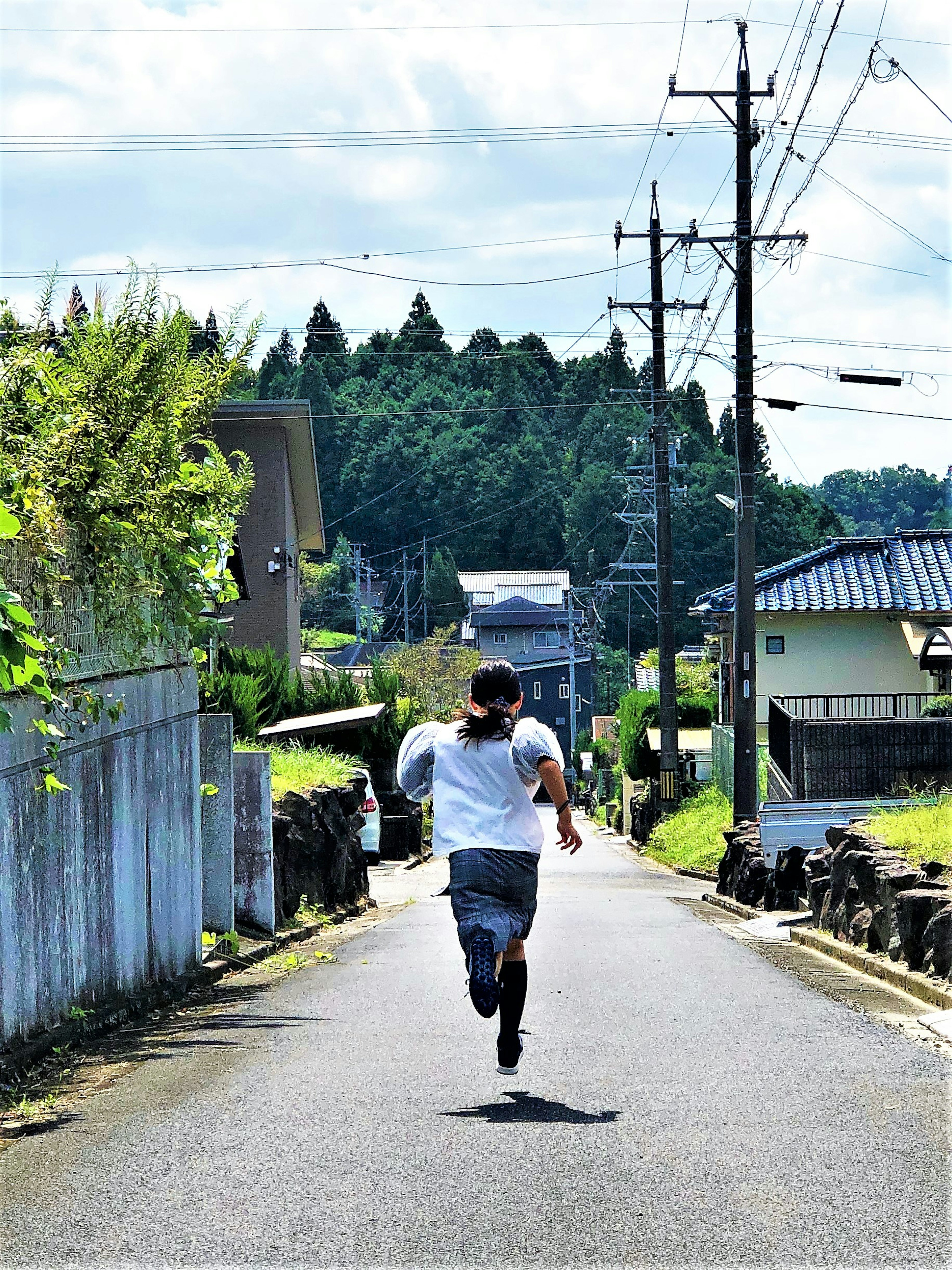 少年が田舎の道を走っている風景