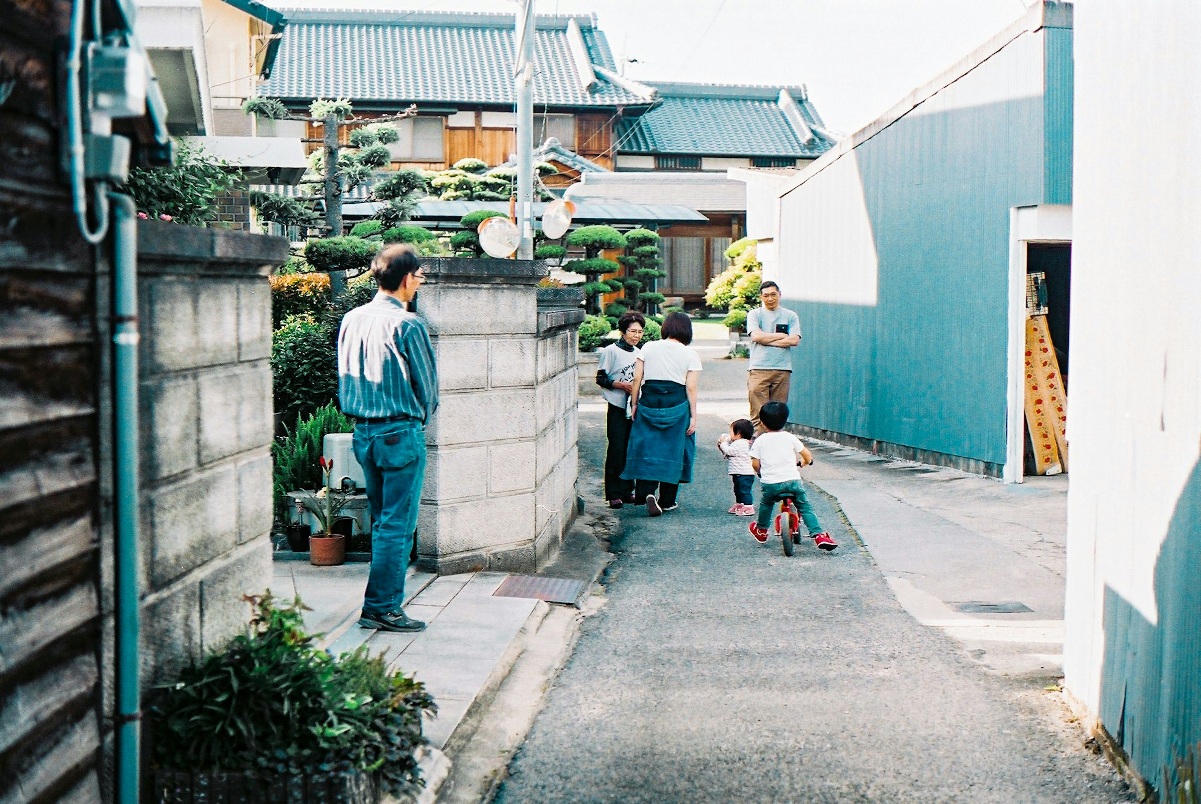 Familienszene in einer engen Gasse mit spielenden Kindern