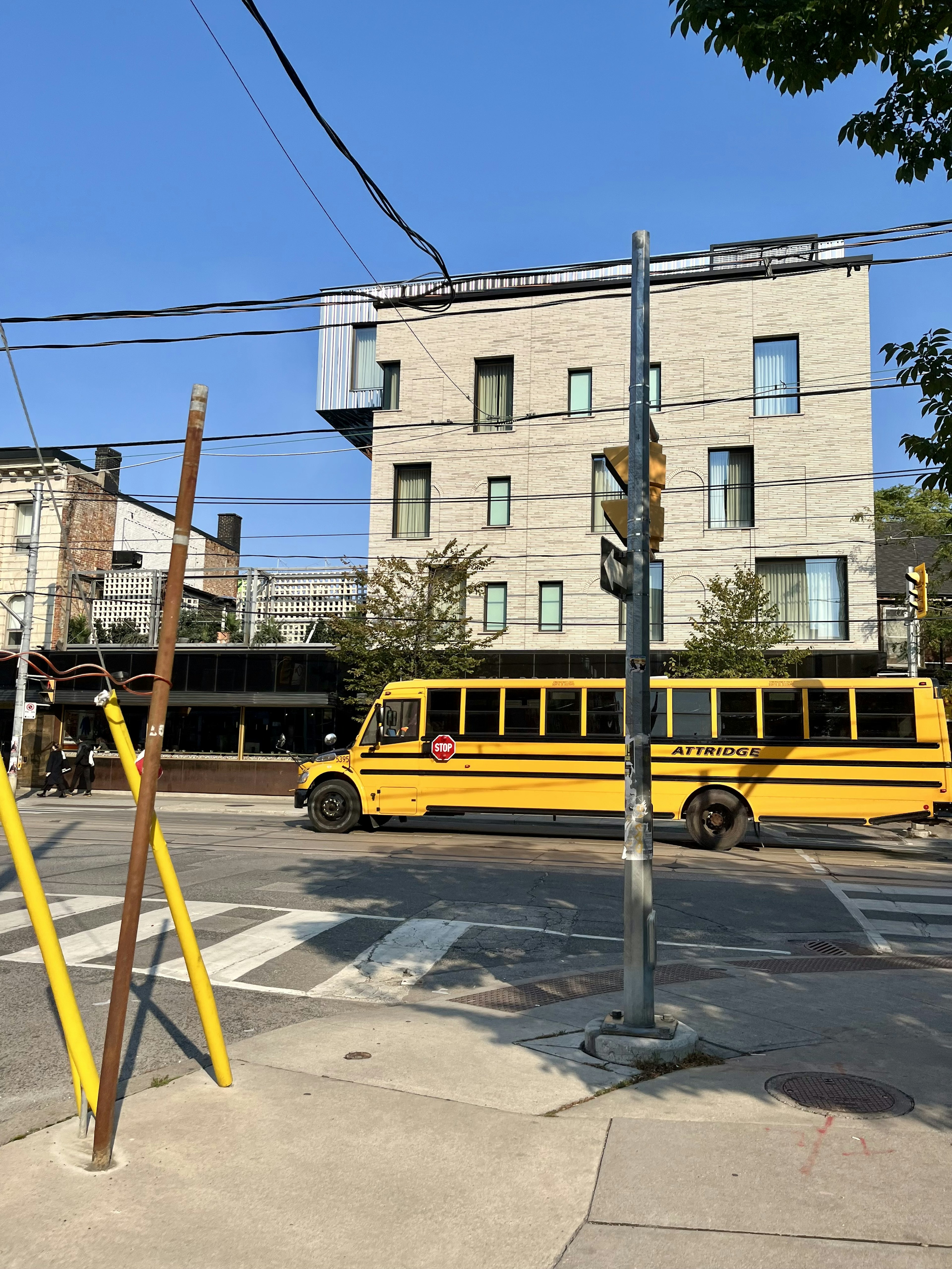 Bâtiment moderne sous un ciel bleu lumineux avec un bus scolaire jaune