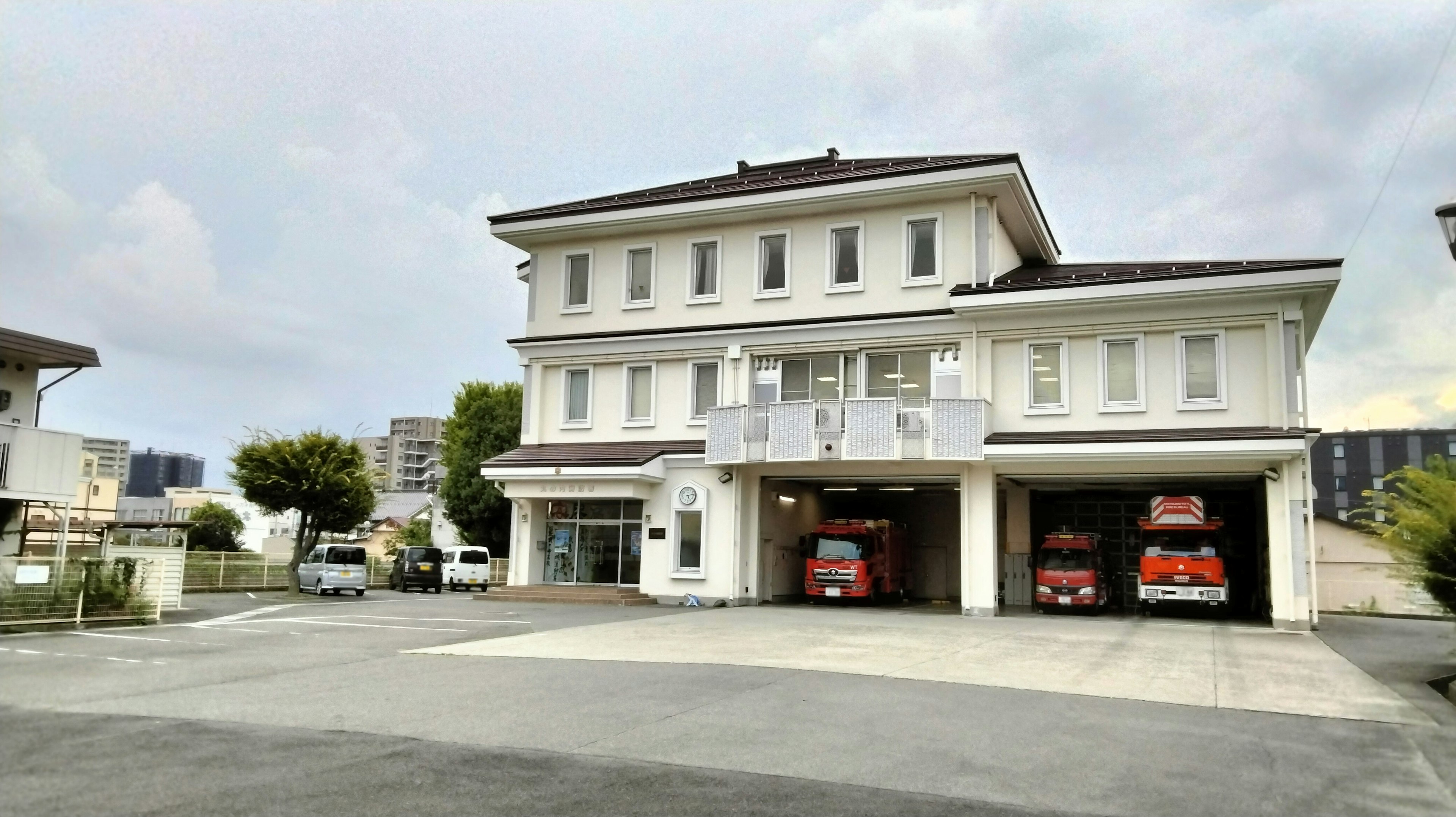 Edificio della stazione dei pompieri con camion dei pompieri rossi visibili