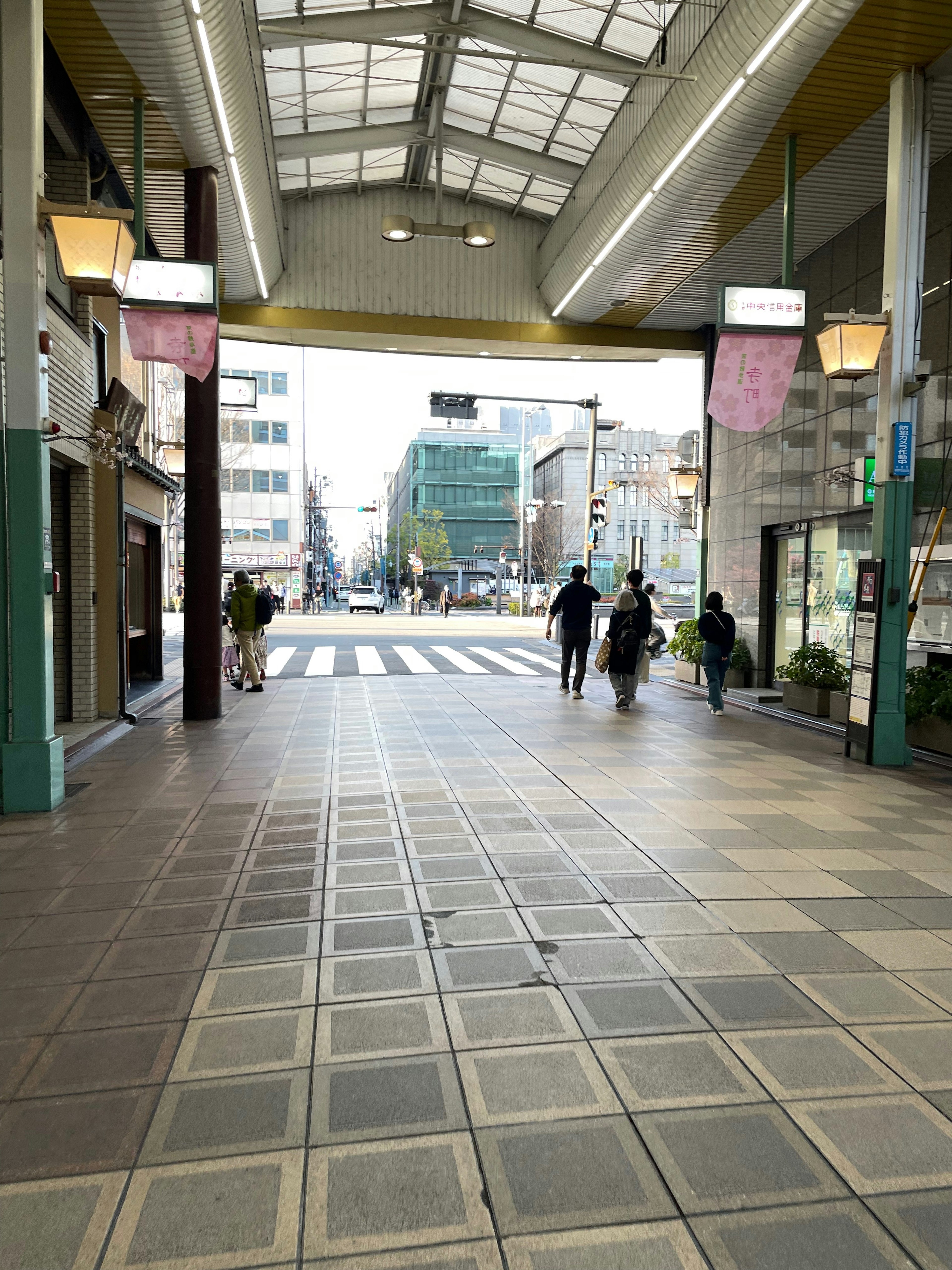 Personas caminando hacia una calle comercial animada