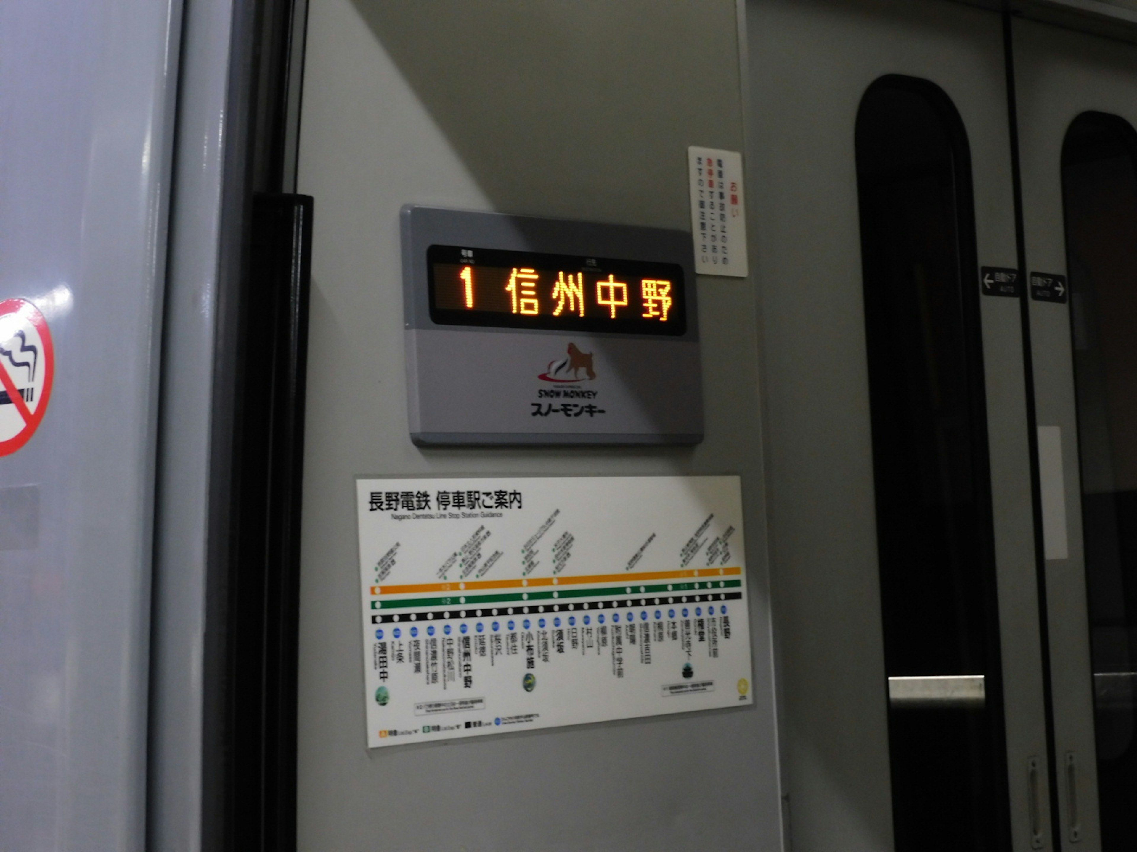 Interior of a train featuring a destination sign and a route map