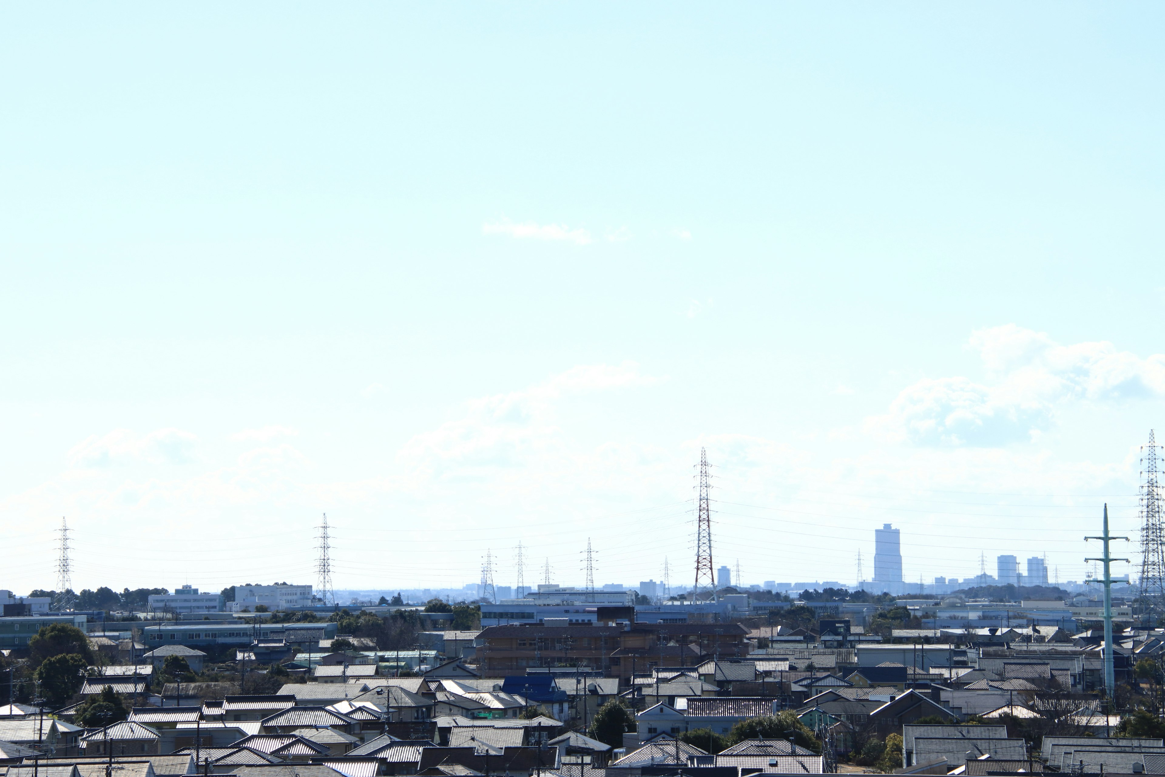 青空の下に広がる都市の風景と高い電波塔