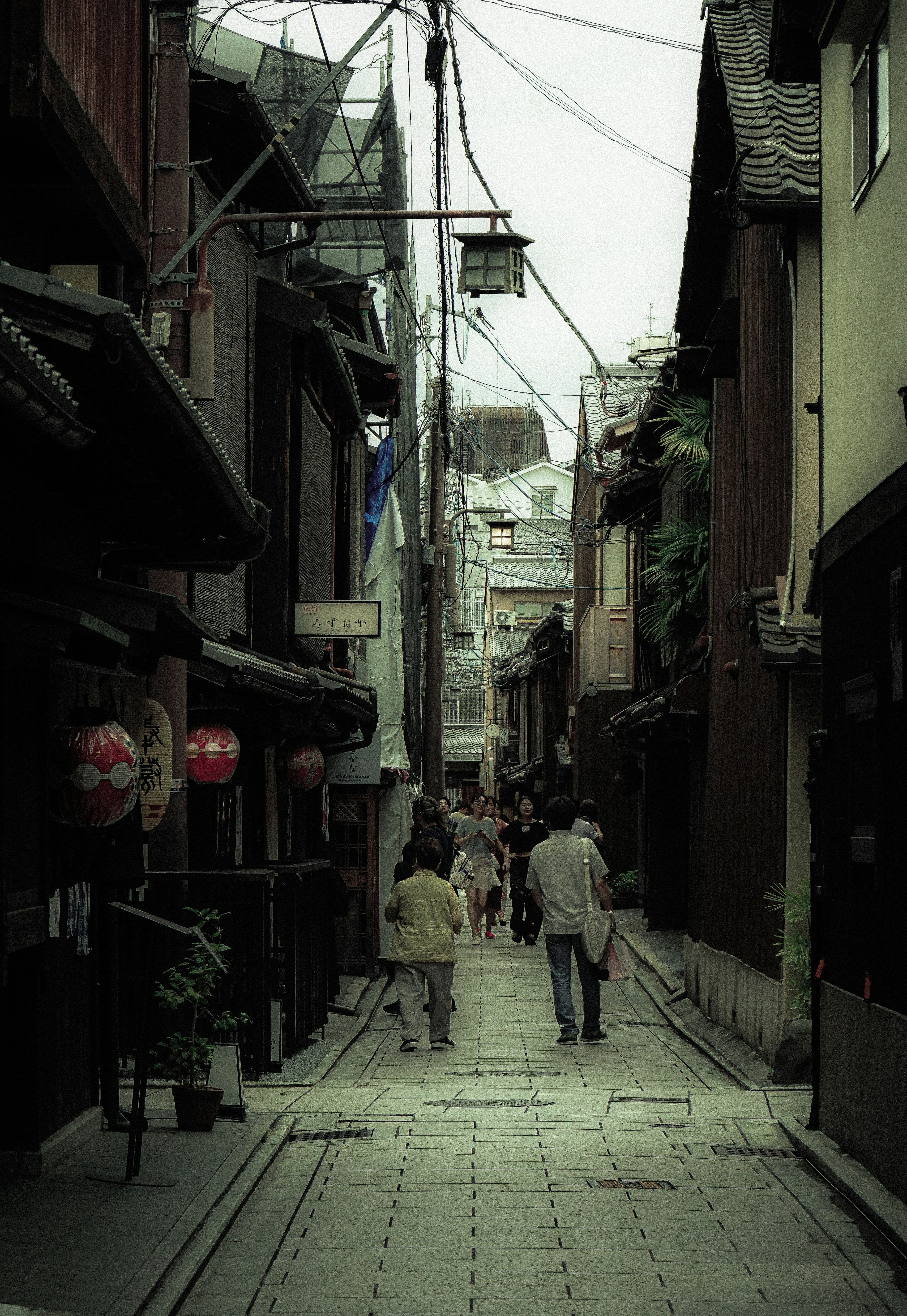 Une ruelle tranquille avec des gens marchant des bâtiments anciens et des lanternes le long de la rue